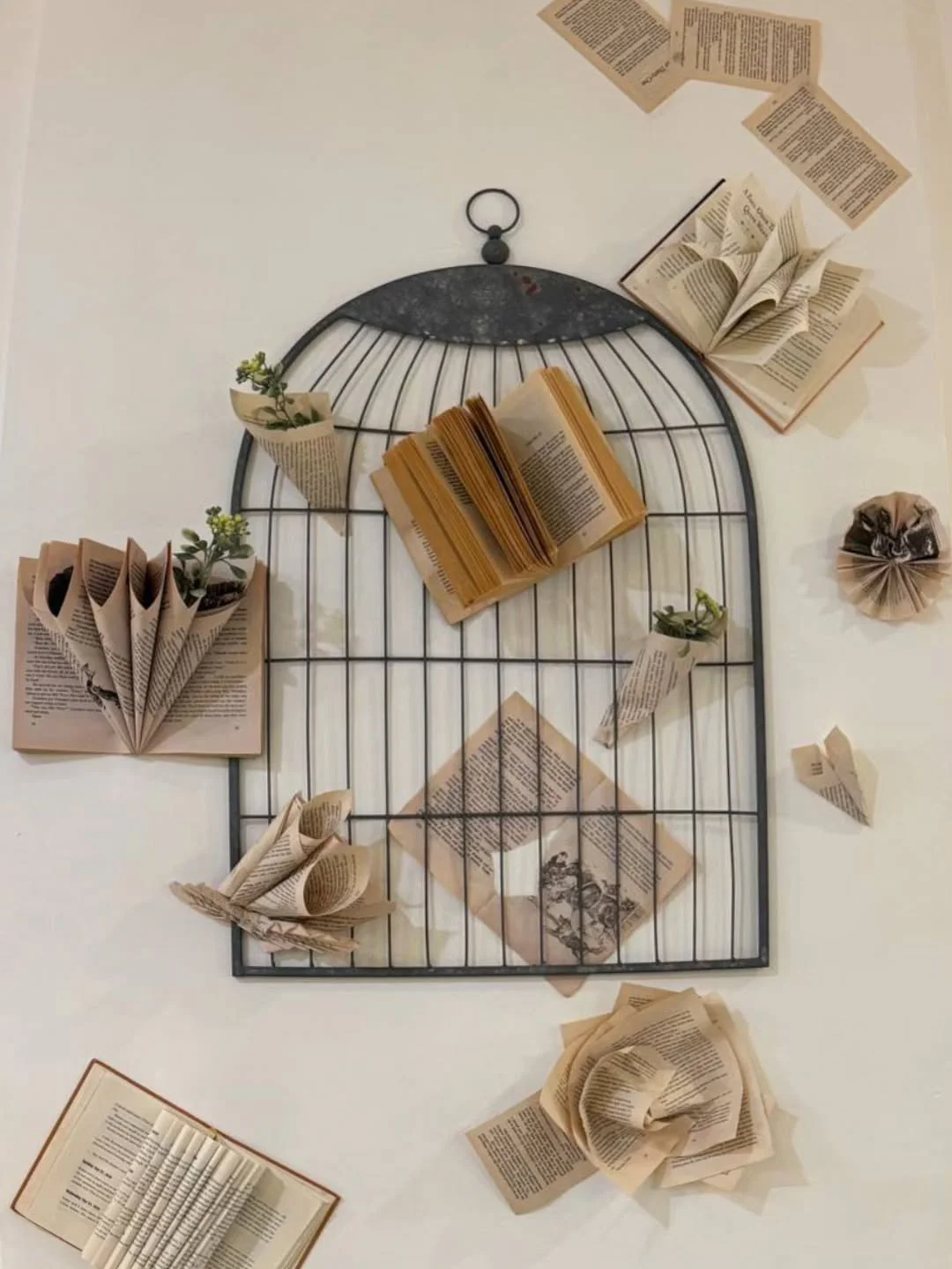 Artistic wall decor featuring books and paper flowers