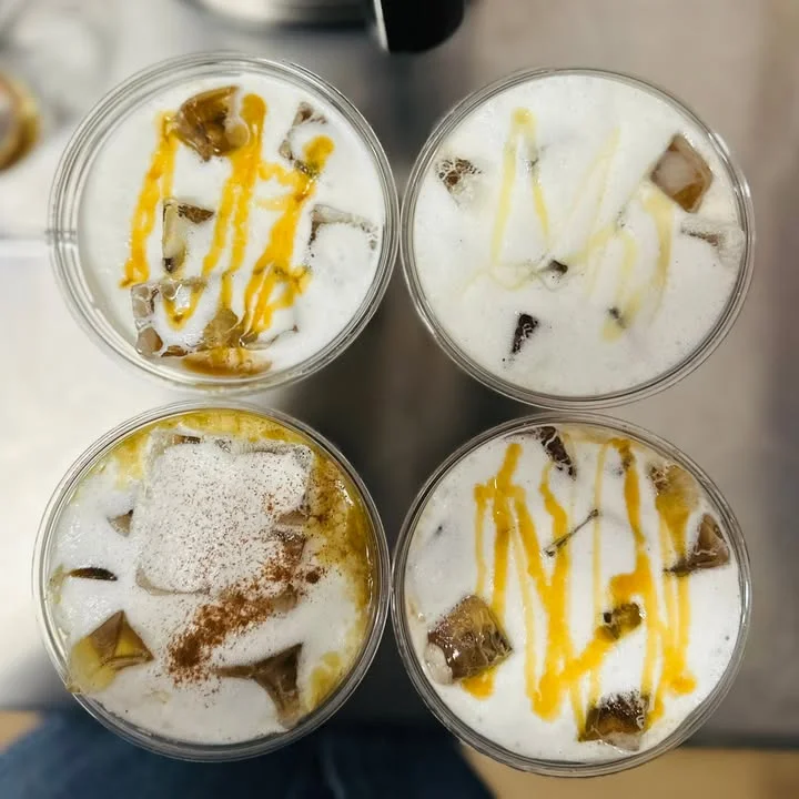 Iced coffee drinks with frothy milk and colorful toppings