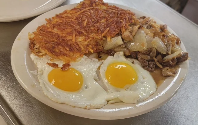 Classic American breakfast with eggs, hash browns, and sautéed mushrooms