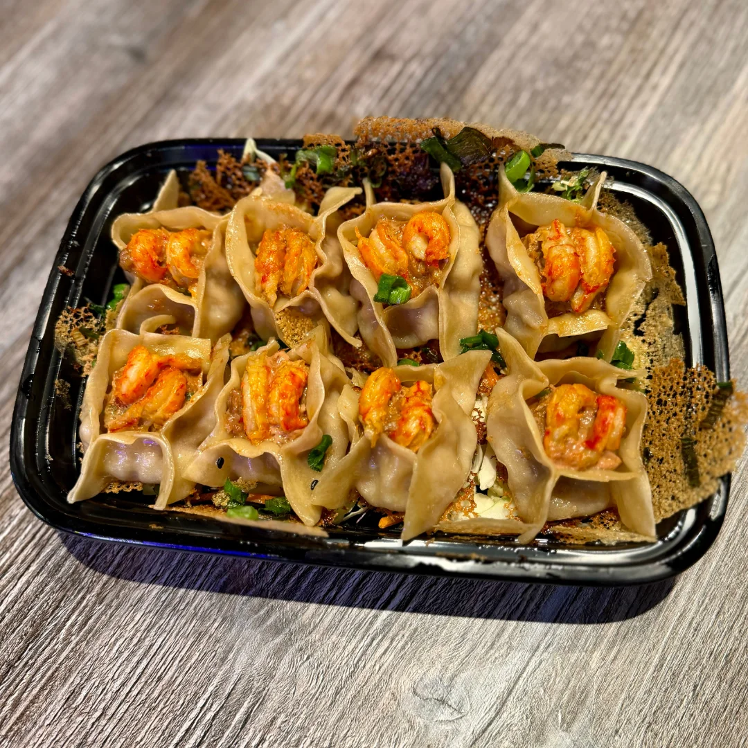 A tray of shrimp dumplings garnished with green onions.
