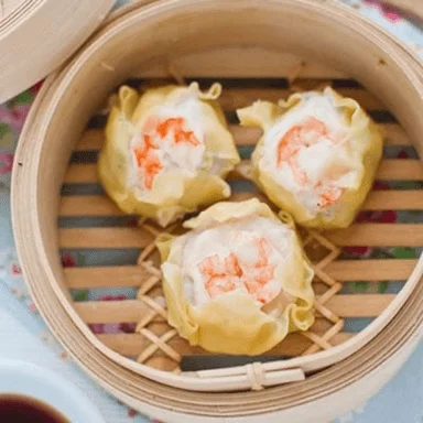 Steamed Chinese siu mai dumplings in a bamboo steamer