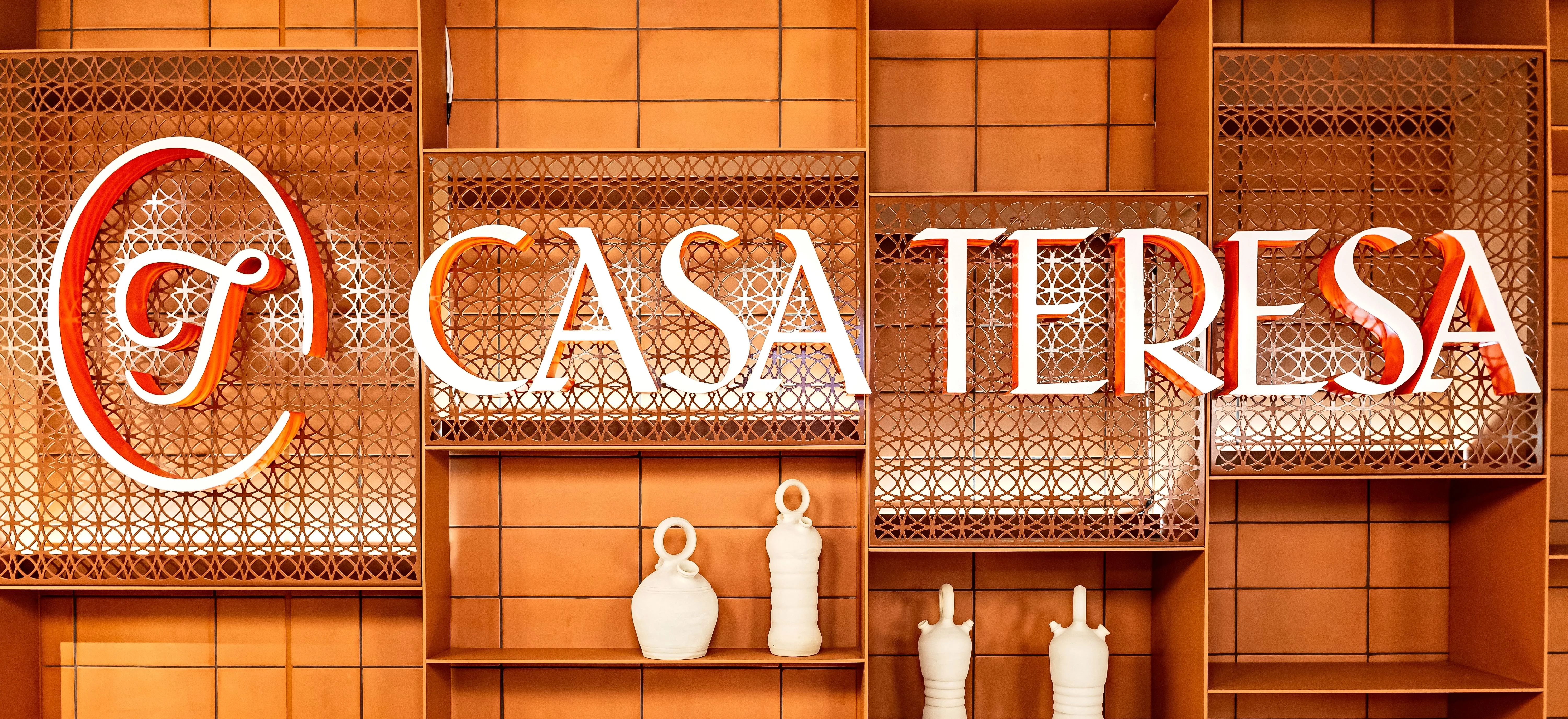 Warm restaurant wall with geometric wood shelving and decorative typography