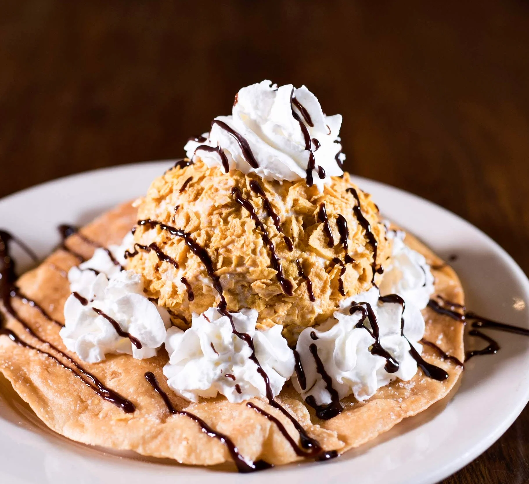Delicious fried ice cream dessert with whipped cream and chocolate drizzle