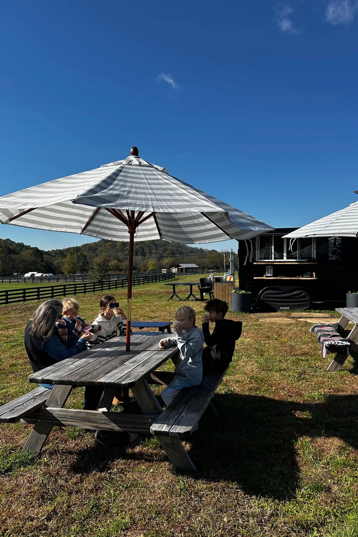 Outdoor dining area with picnic tables and umbrellas on a sunny day