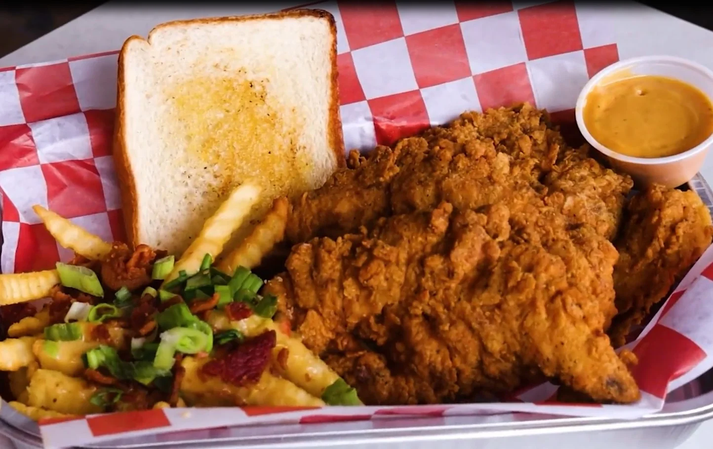 Southern fried chicken platter with mac and cheese, fries, toast, and dipping sauce