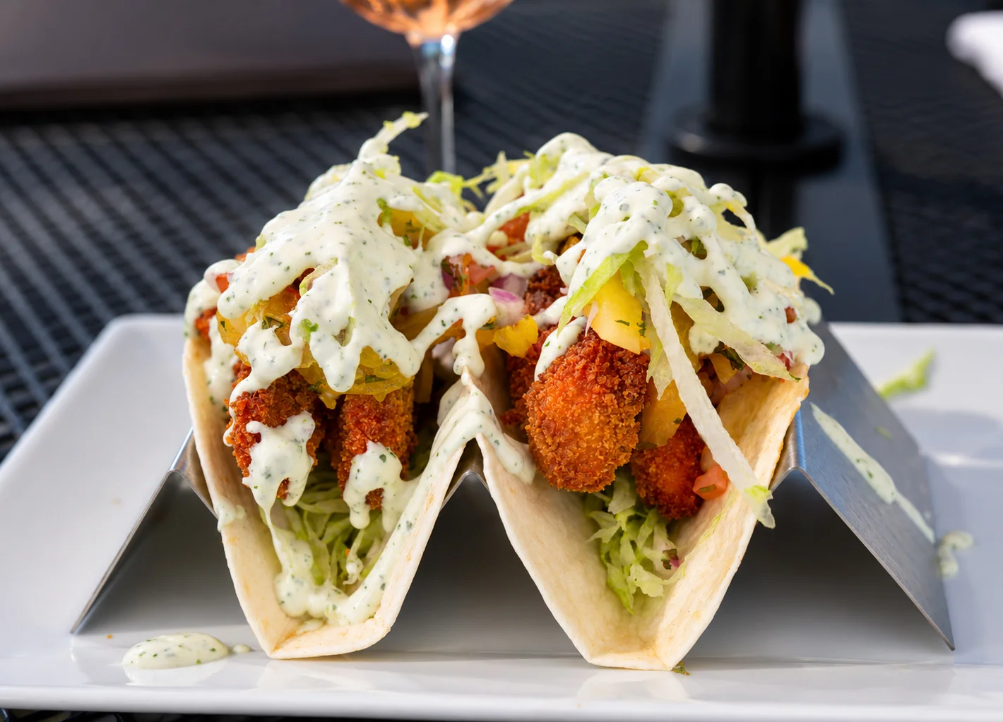 Crispy fish tacos topped with creamy sauce