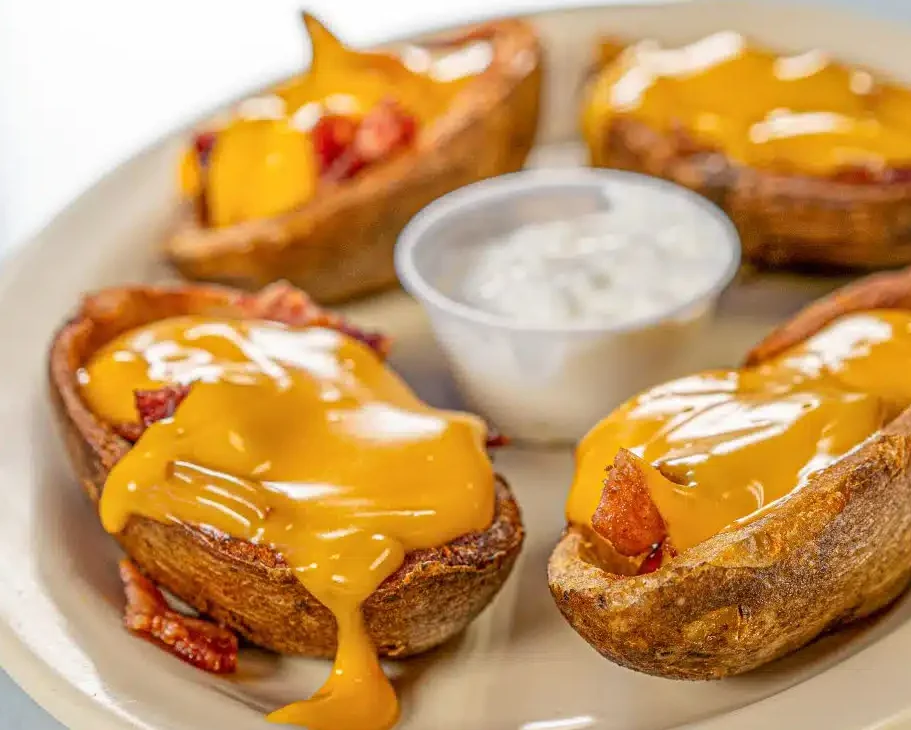  Potato skins topped with melted cheddar cheese, served with sour cream dressing.