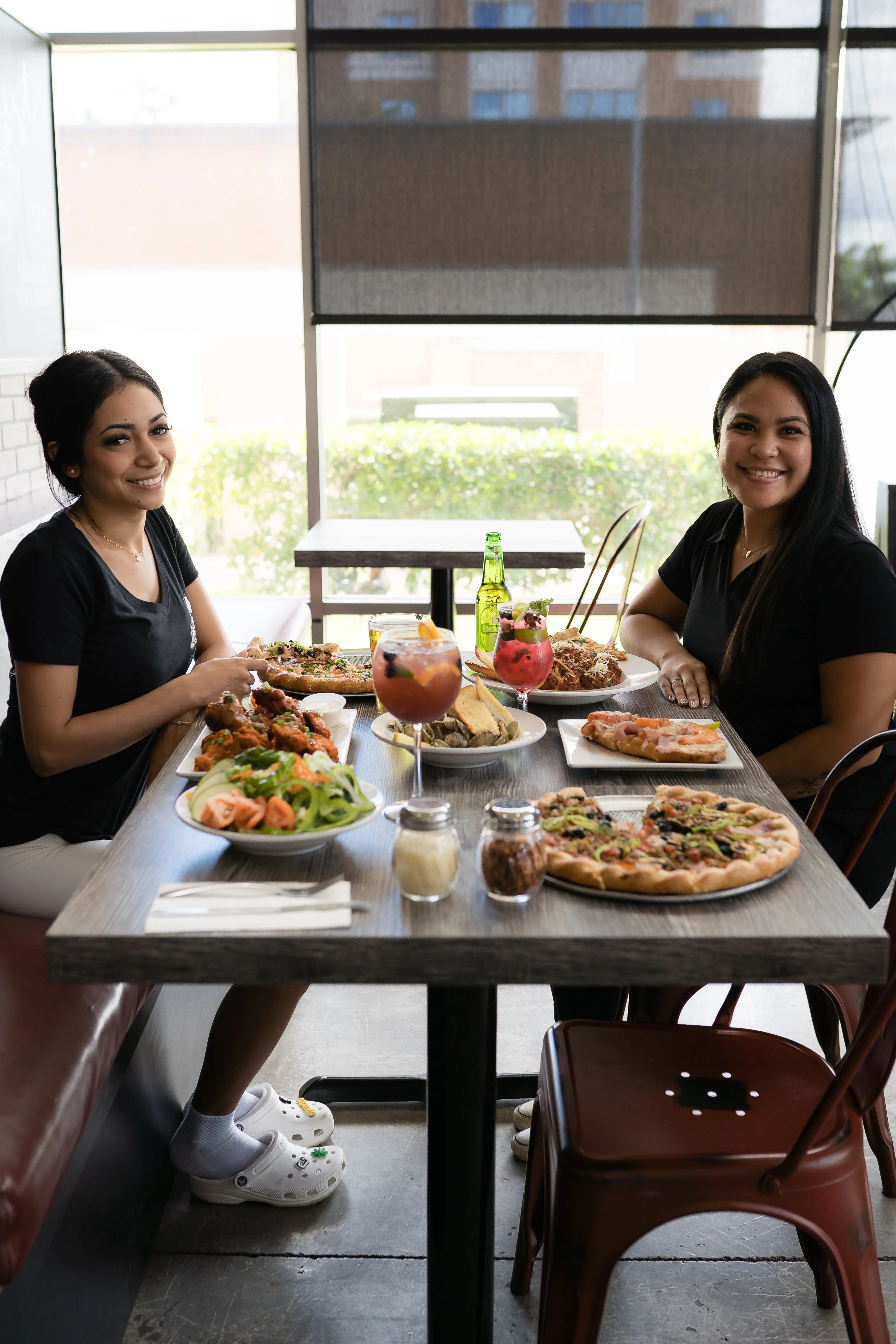 Two friends enjoying a variety of dishes in a cozy restaurant setting