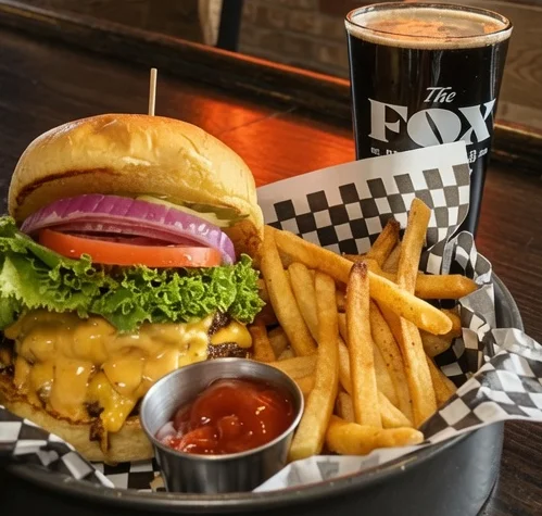 Juicy cheeseburger with fries and craft beer