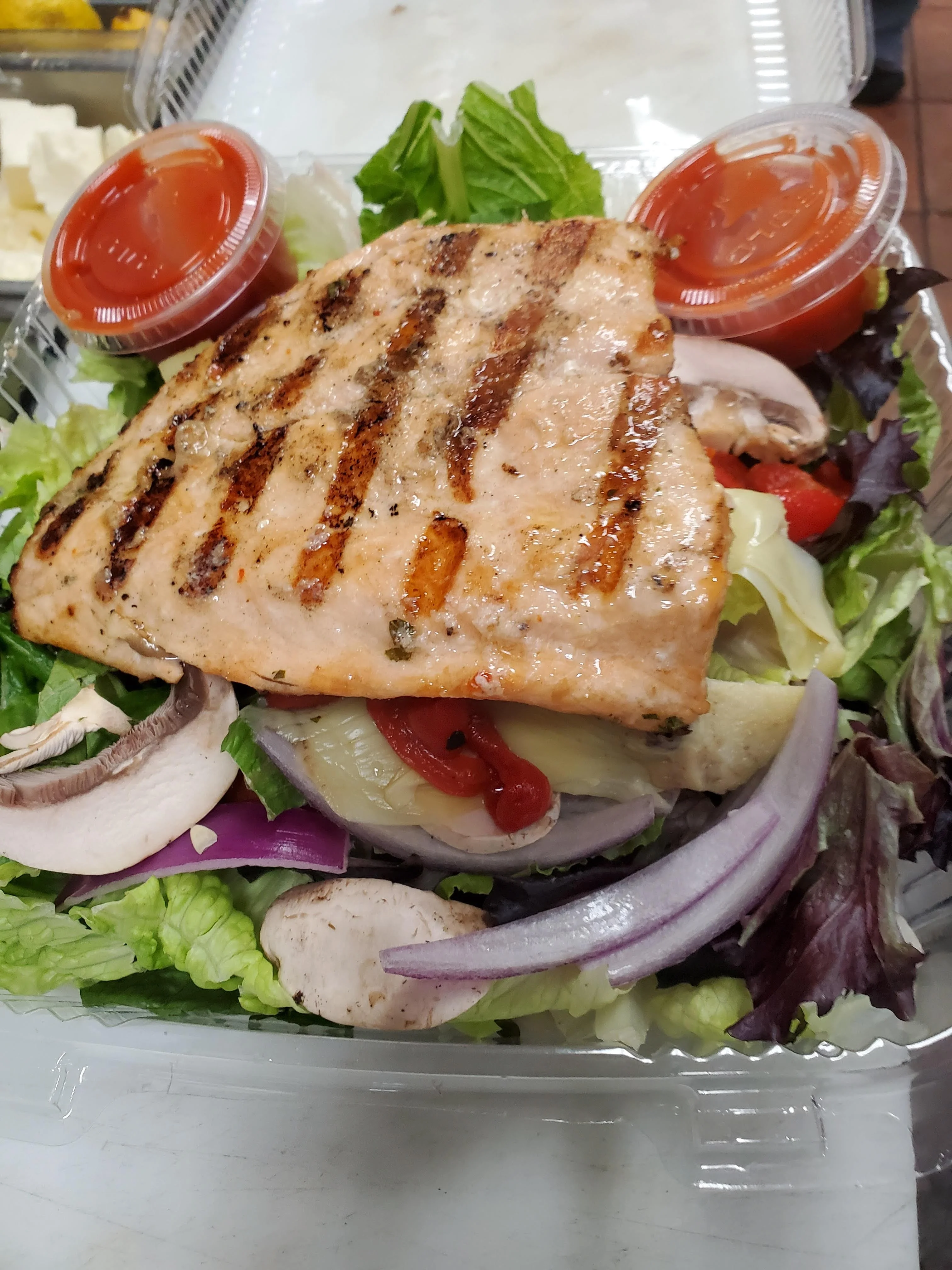 Grilled salmon salad with fresh greens and dressing