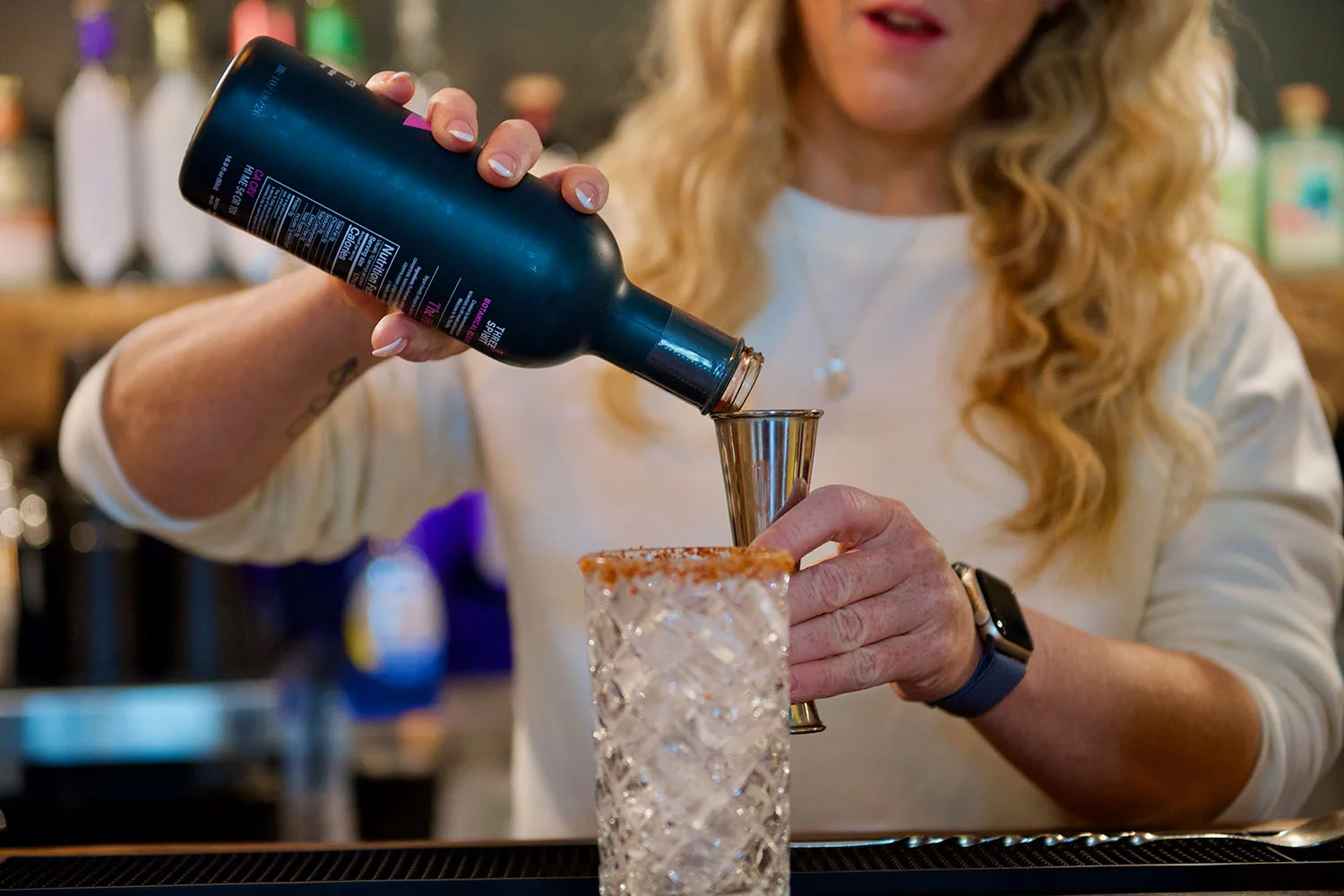 A woman bartender is making a zero-proof cocktail
