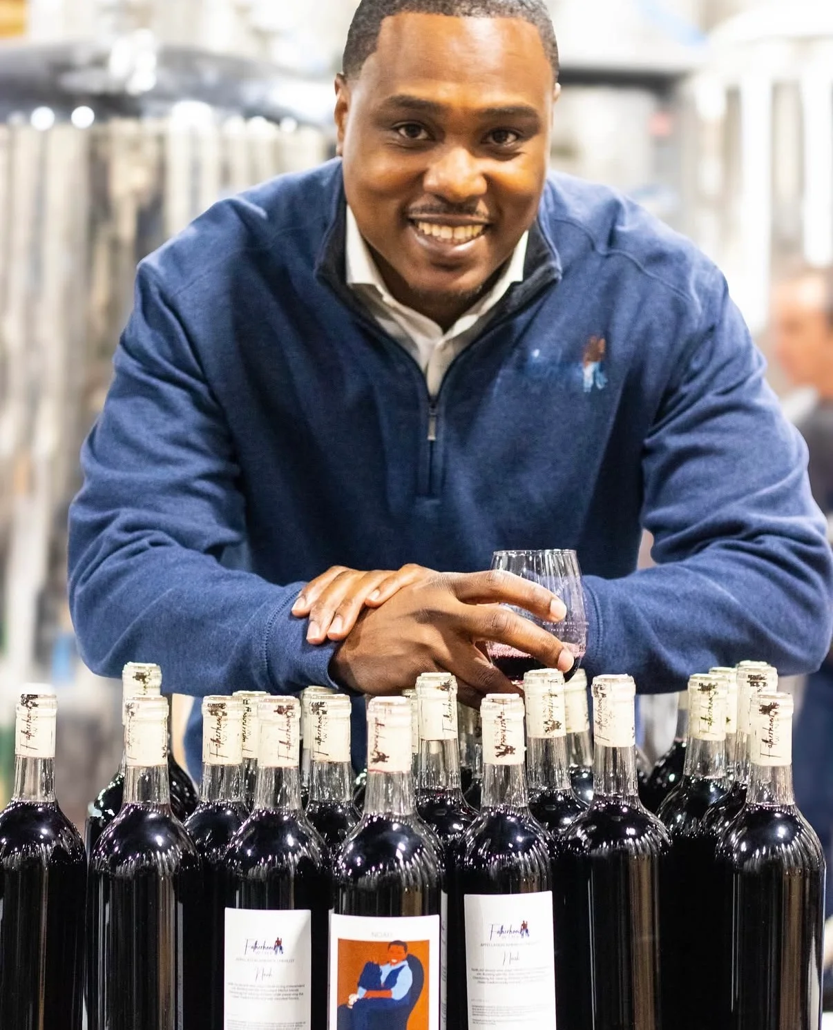 Winemaker showcasing bottles of red wine at a tasting event