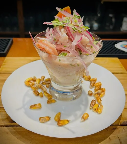 Peruvian ceviche served in a glass with onions and herbs