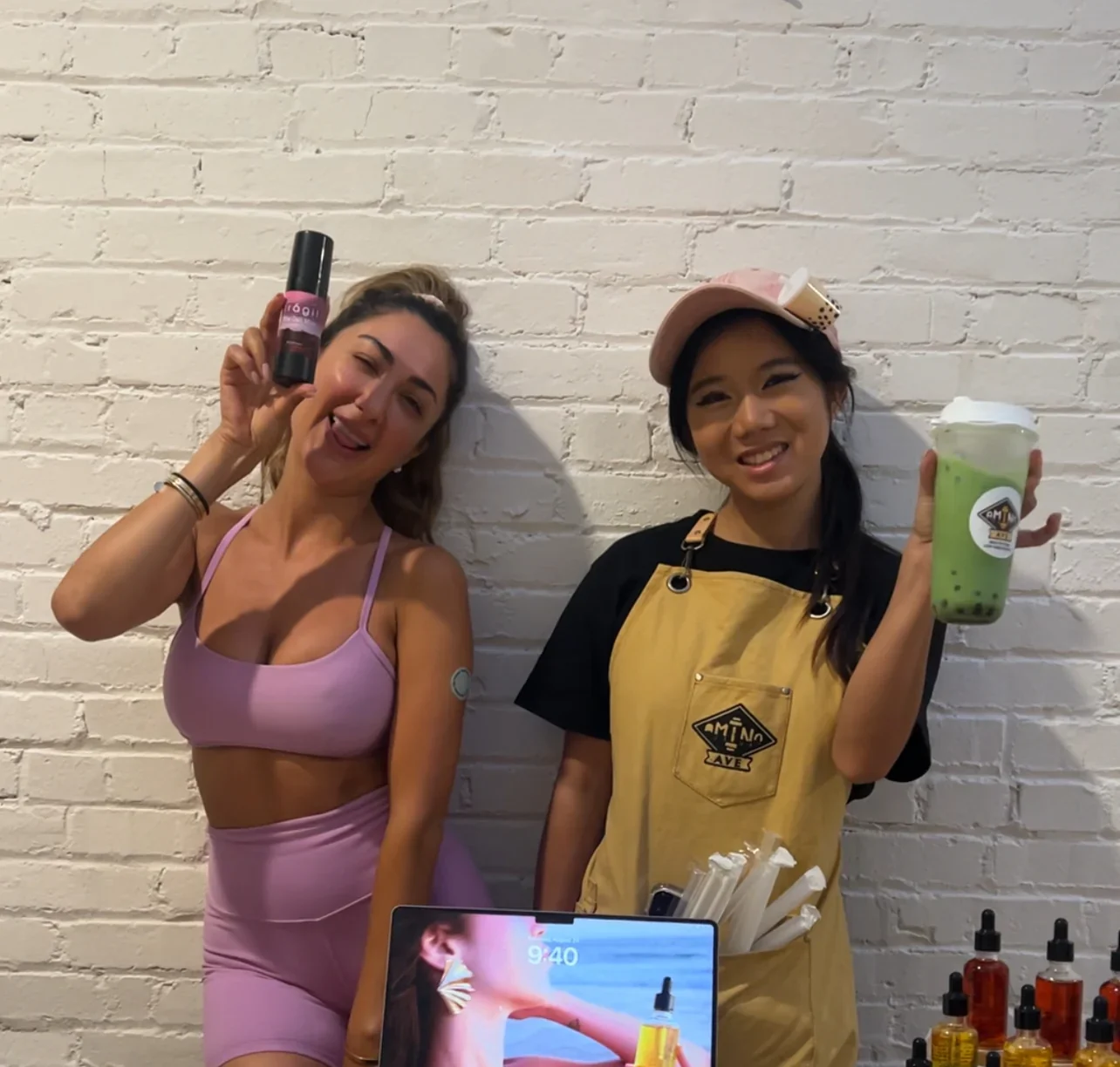 Two women at a trendy cafe showcasing drinks and products