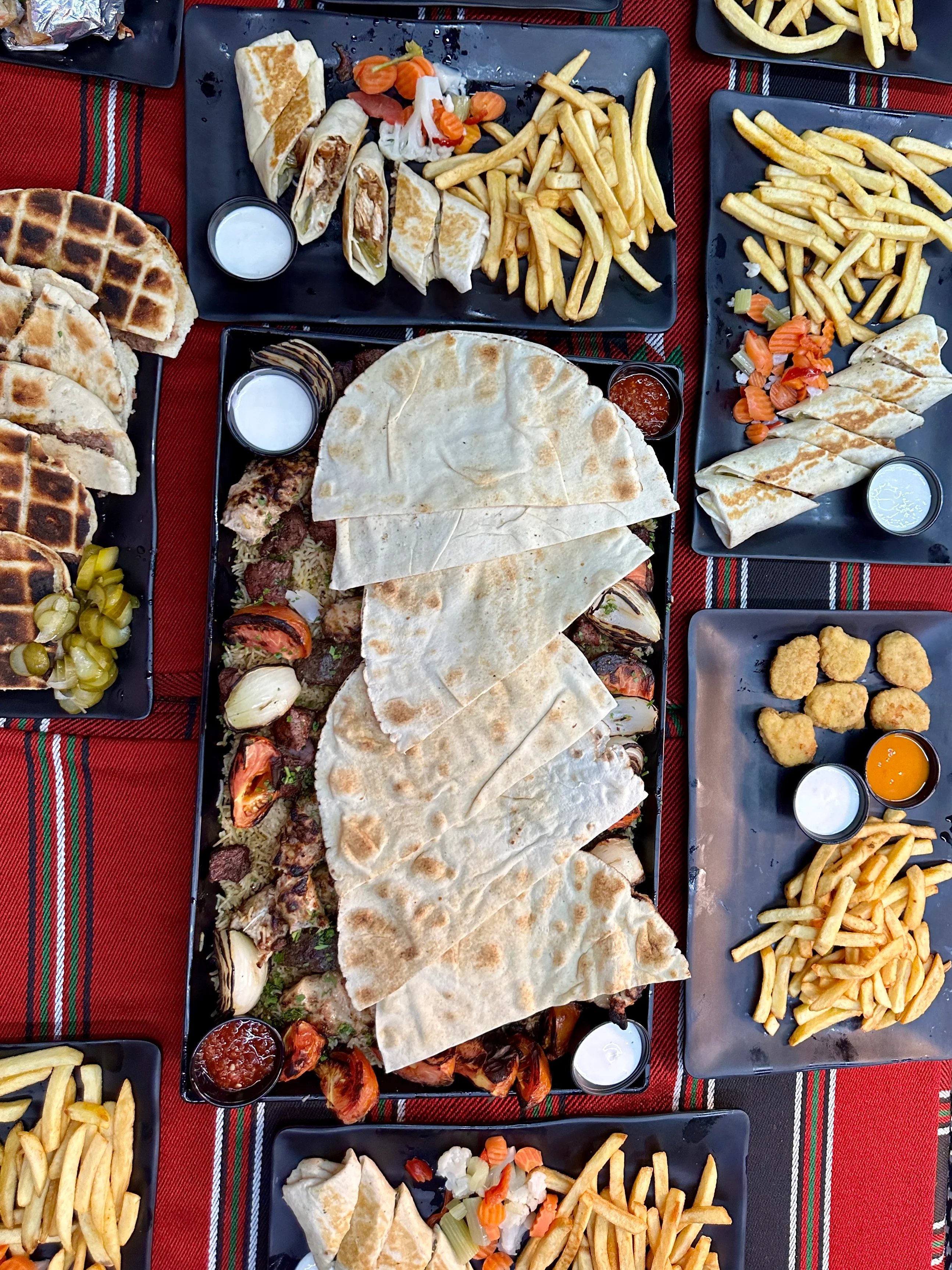 Middle Eastern mixed grill platter with flatbreads and sides