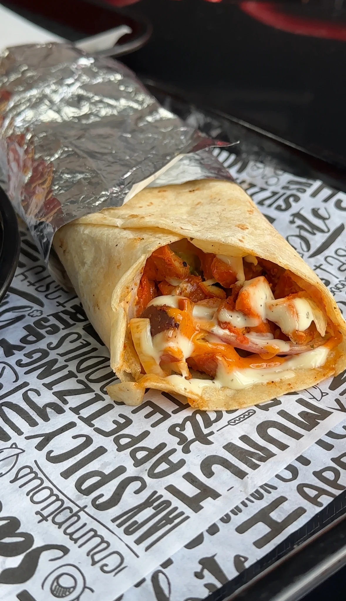 Delicious wrap filled with fresh ingredients on a wooden table.