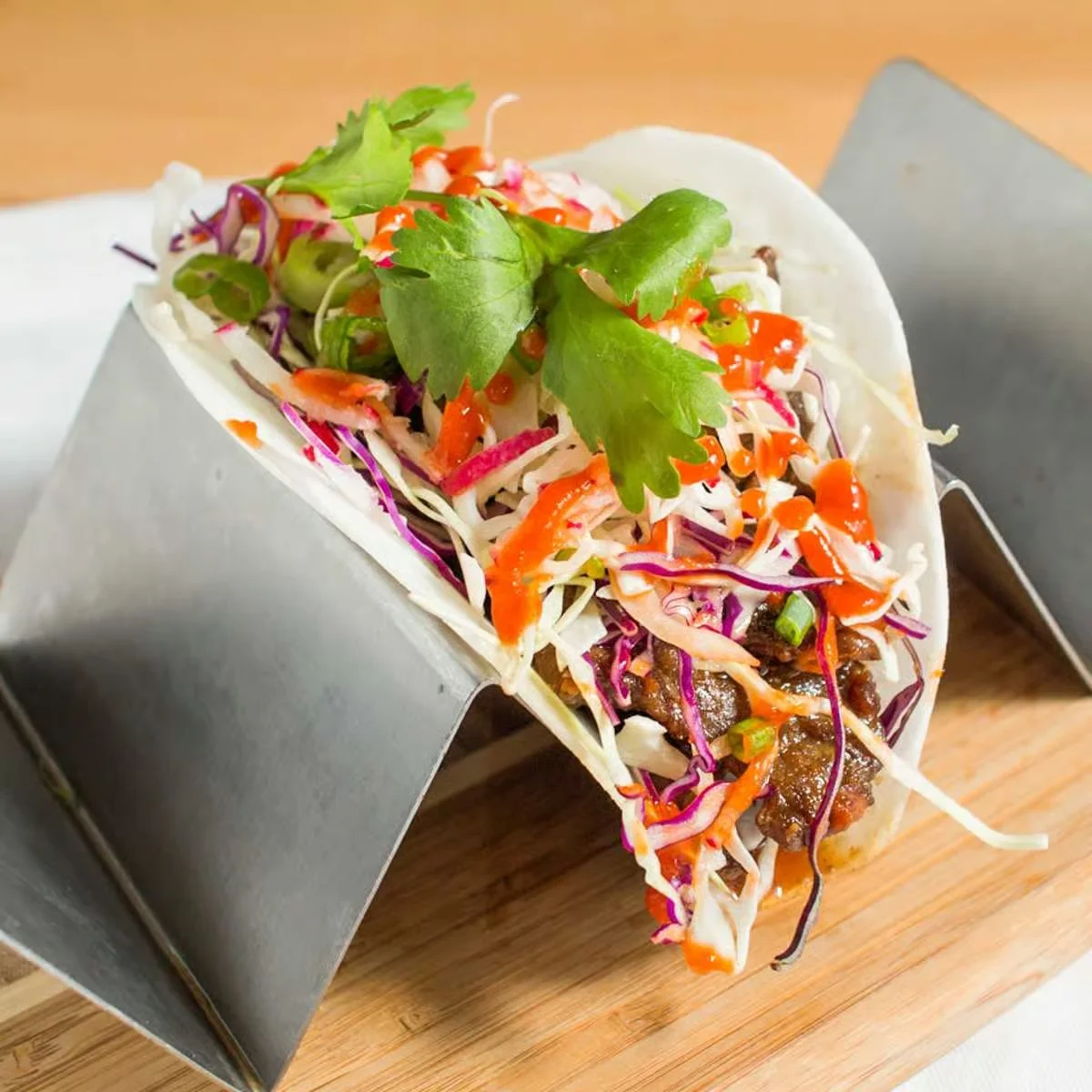 Delicious street taco topped with fresh vegetables and cilantro
