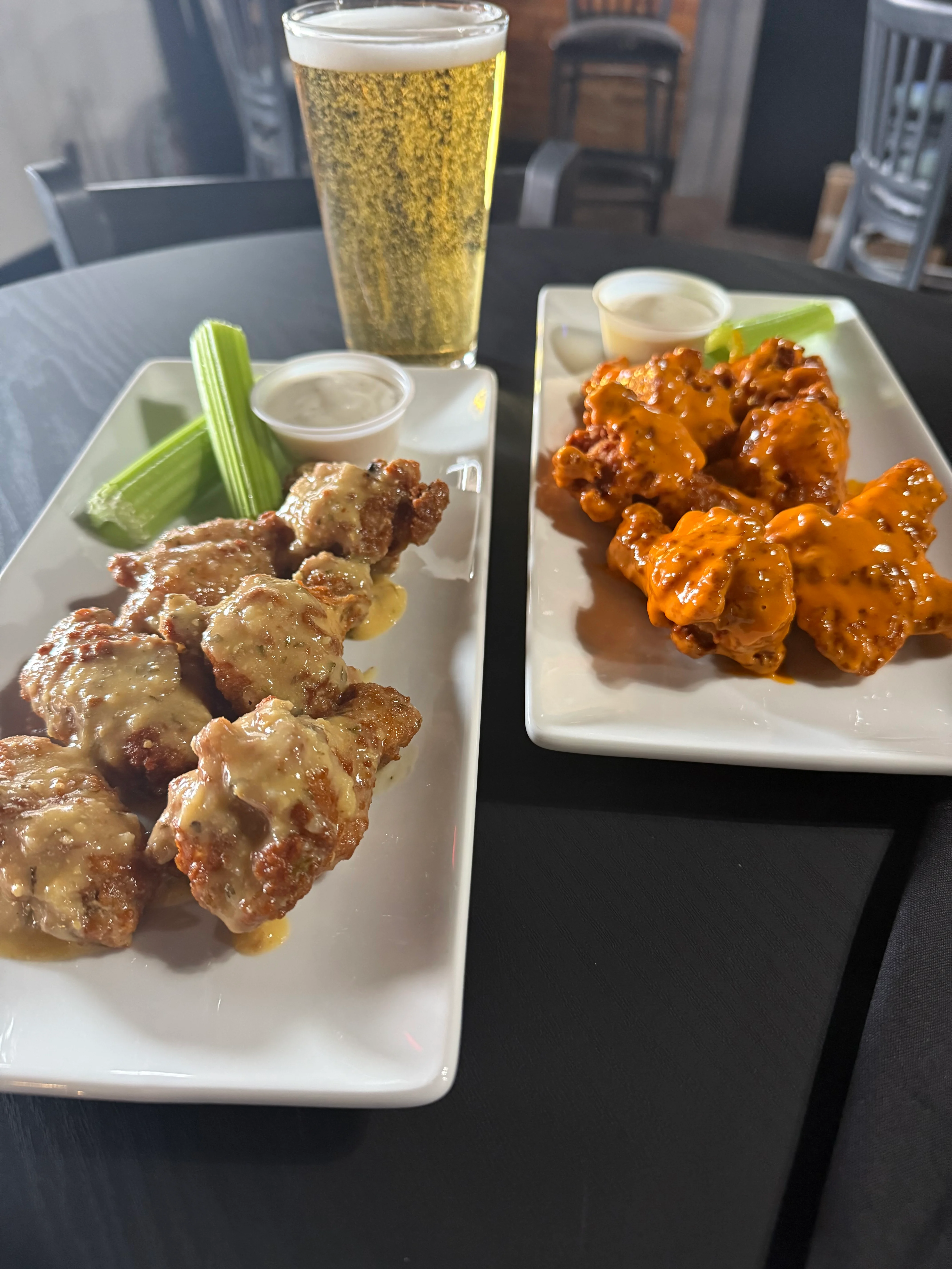 Buffalo wings with ranch and celery in a casual dining setting