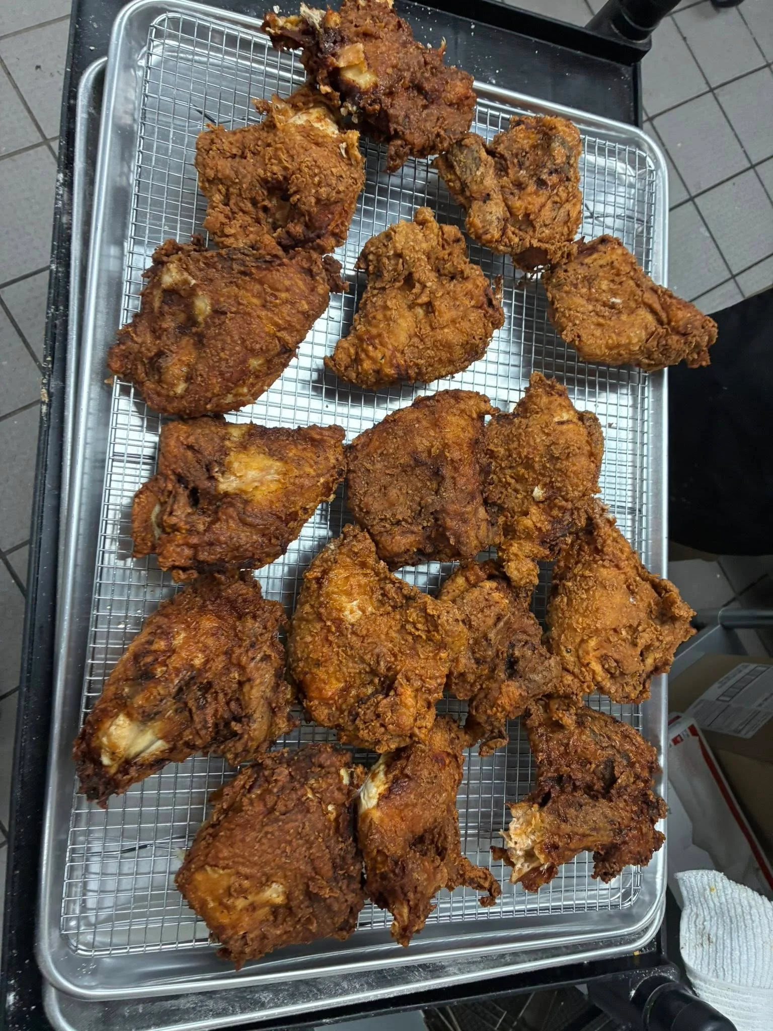 Tray of freshly fried chicken pieces on a cooling rack.