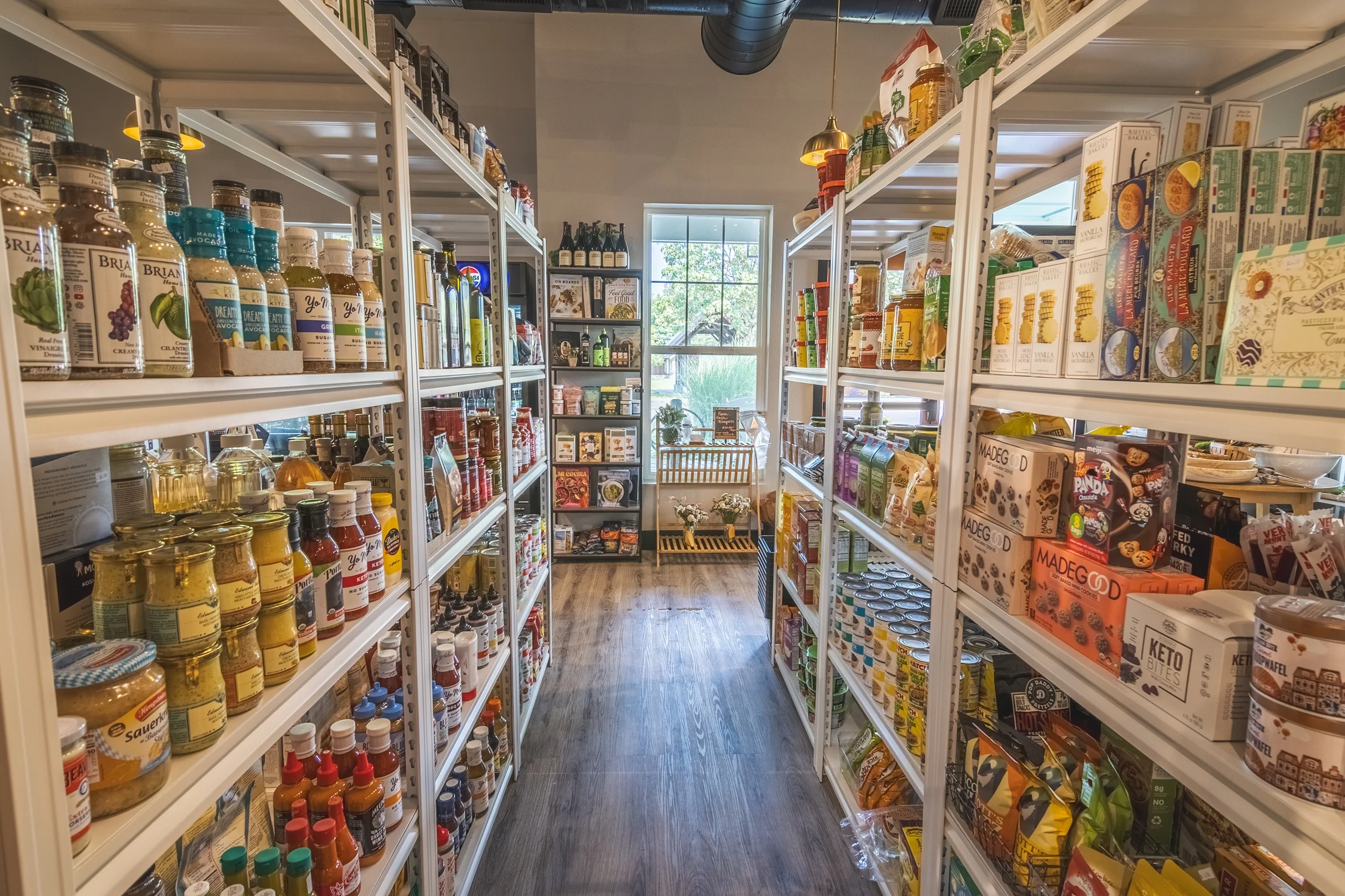 Aisles of a gourmet grocery store filled with various sauces and snacks