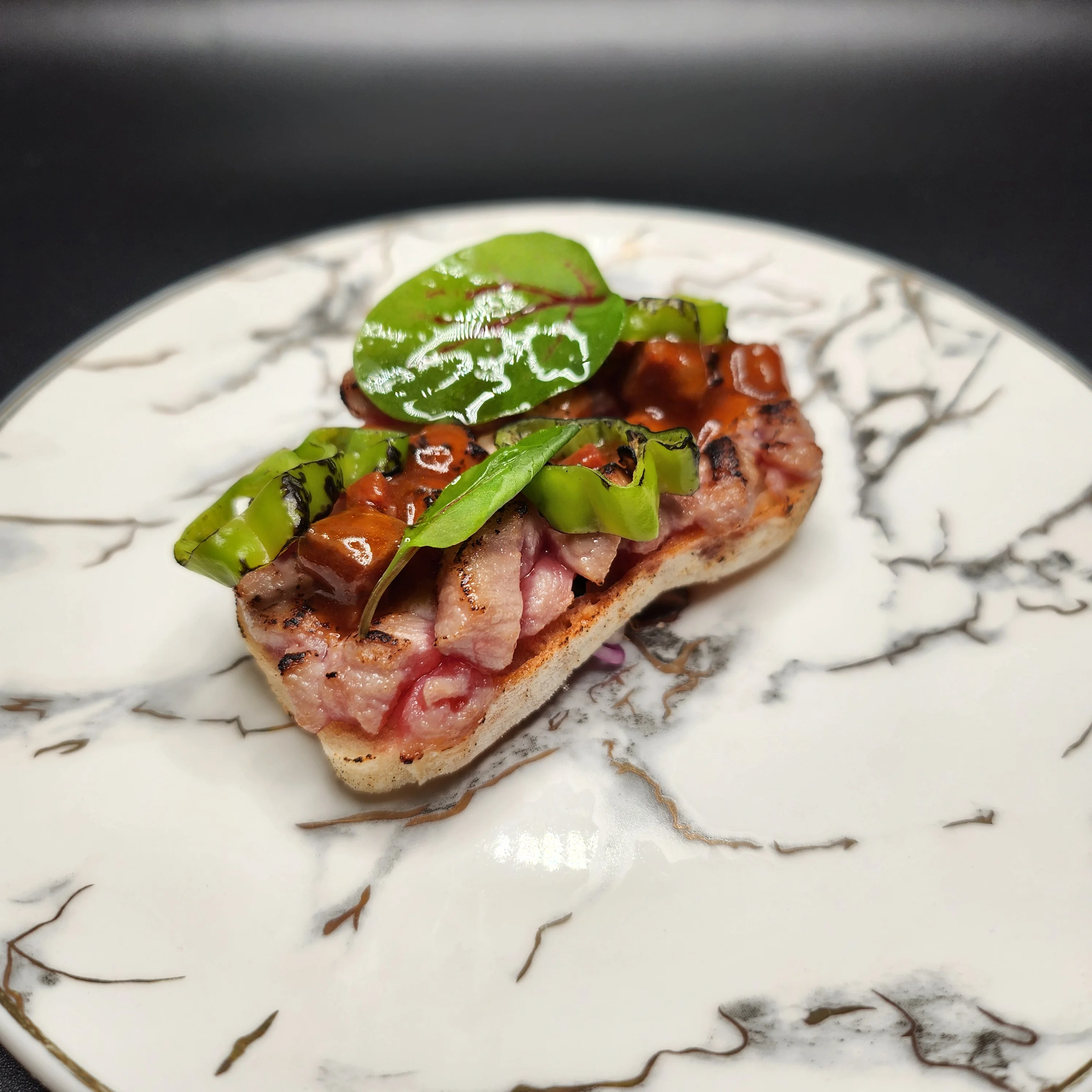 Plate of Iberico presa, a gourmet Spanish dish with vibrant presentation.