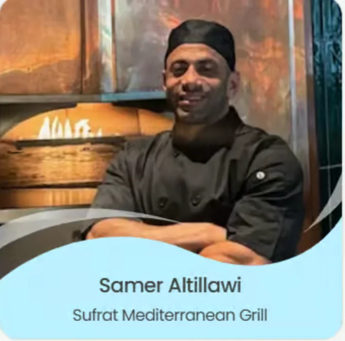 A dark-skinned man wearing a black chef outfit stands with his arms crossed across his chest, standing in front of a wooden fireplace. A blue banner across the photo displays his name, ‘Samer Altillawi,’ and his restaurant, ‘Sufrat Mediterranean Grill.’
