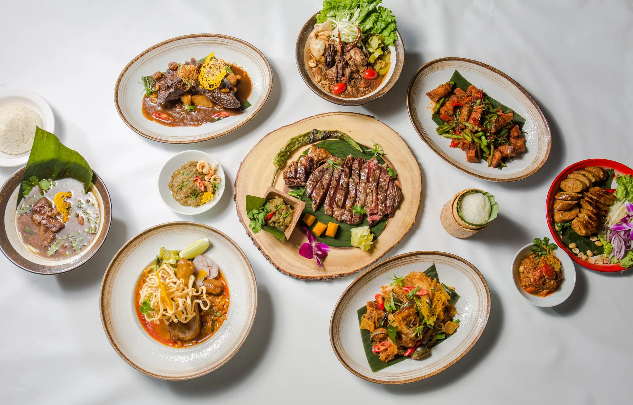 Assorted Thai dishes including grilled beef and spicy salads