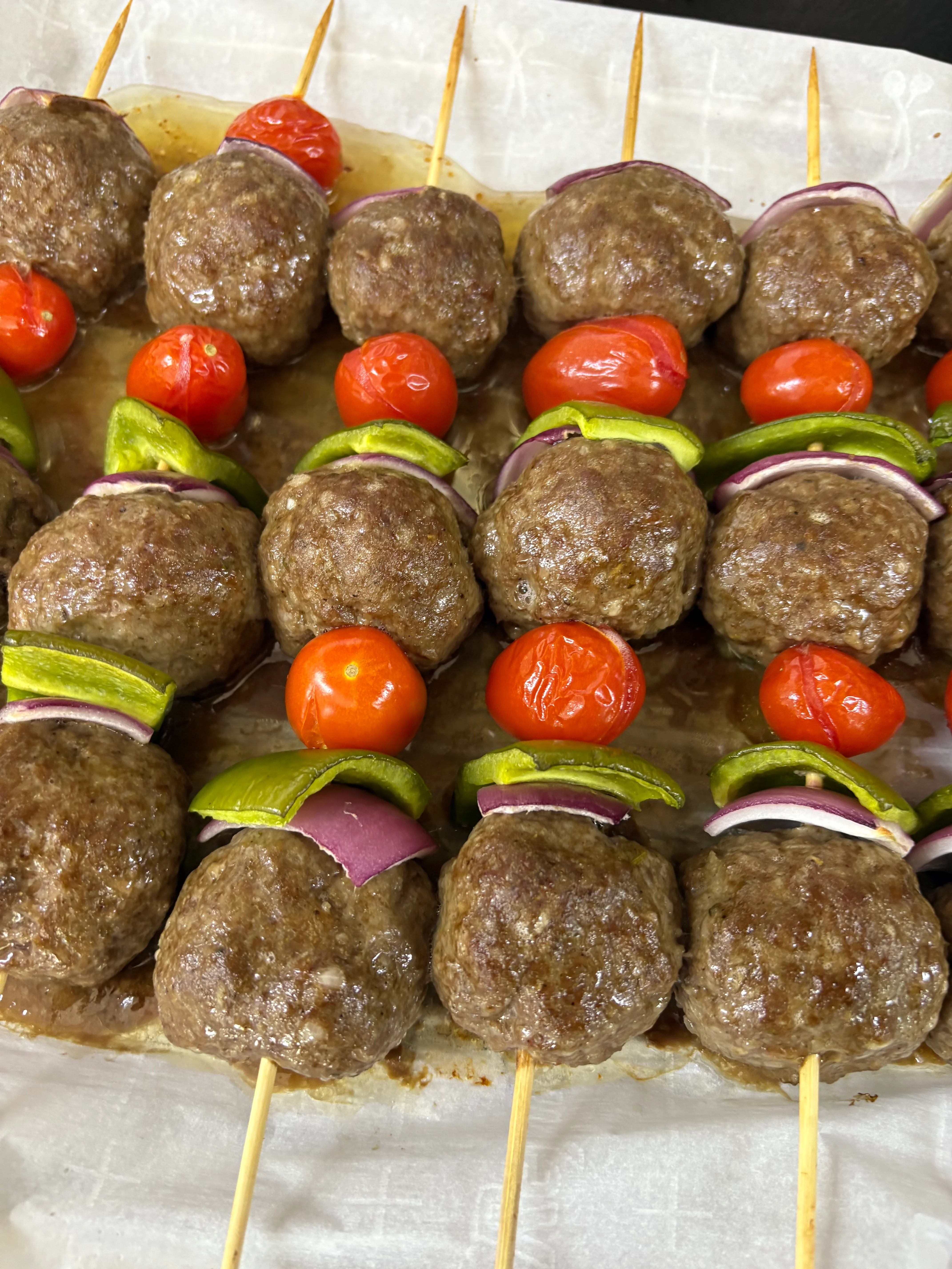 Grilled kebabs with meatballs, tomatoes, and peppers on skewers