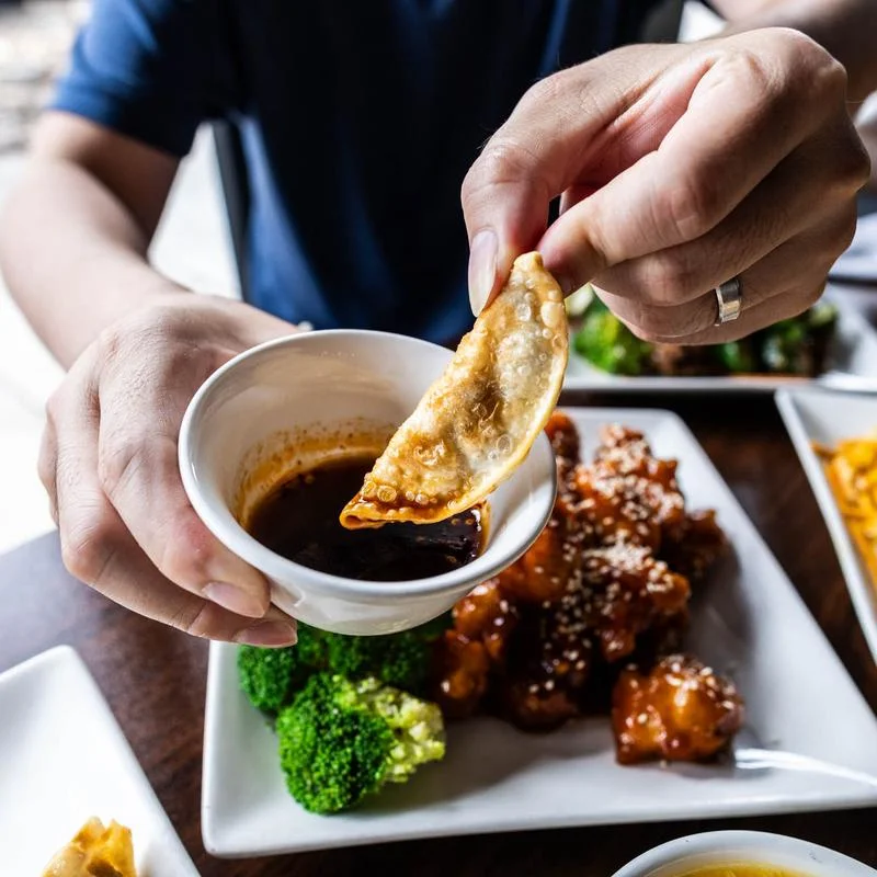 Assorted Chinese dumplings and spring rolls on a wooden table