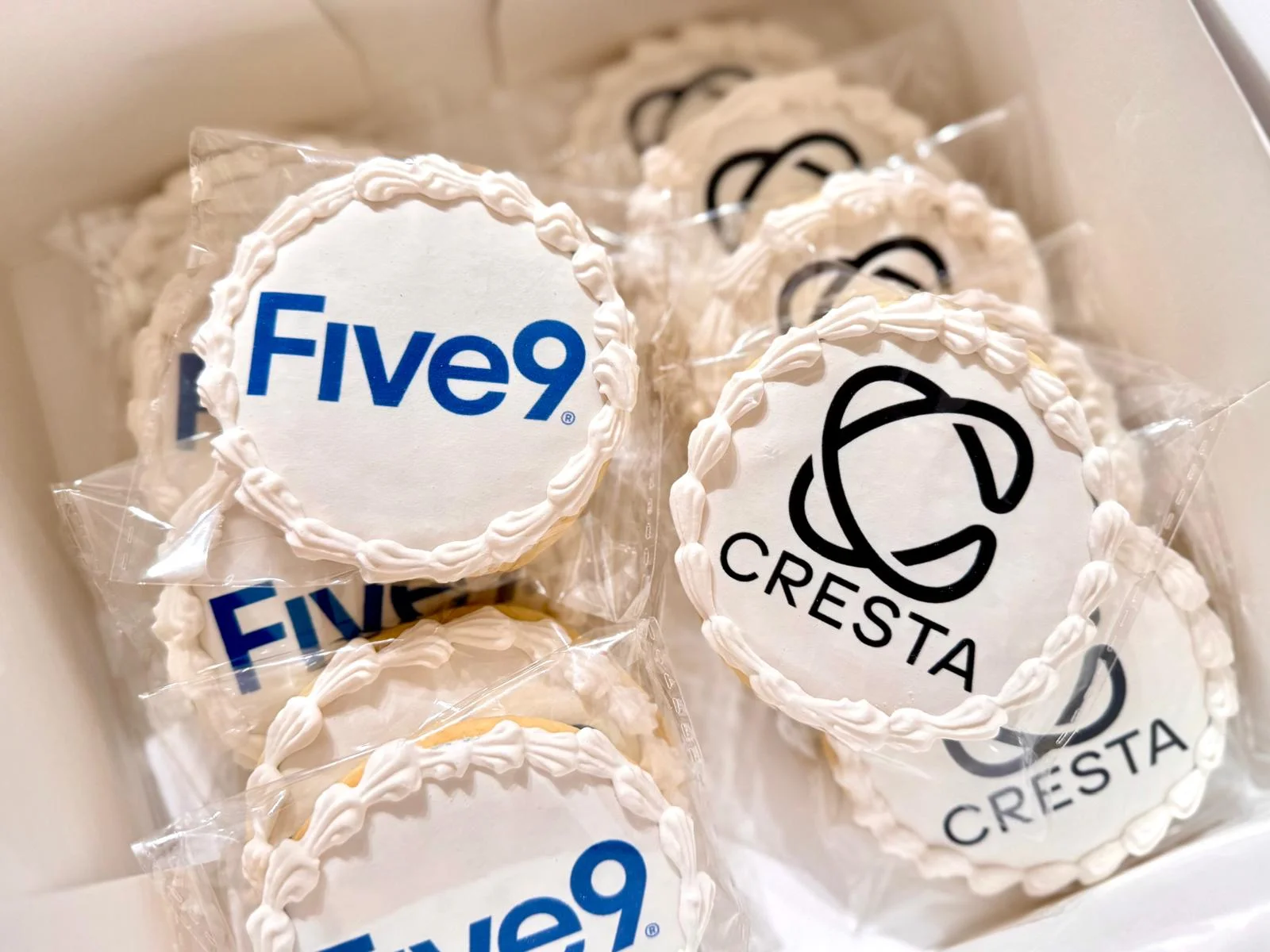 Decorative cookies featuring company logos in a gift box