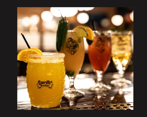 Colorful cocktails on a bar counter at a lively restaurant
