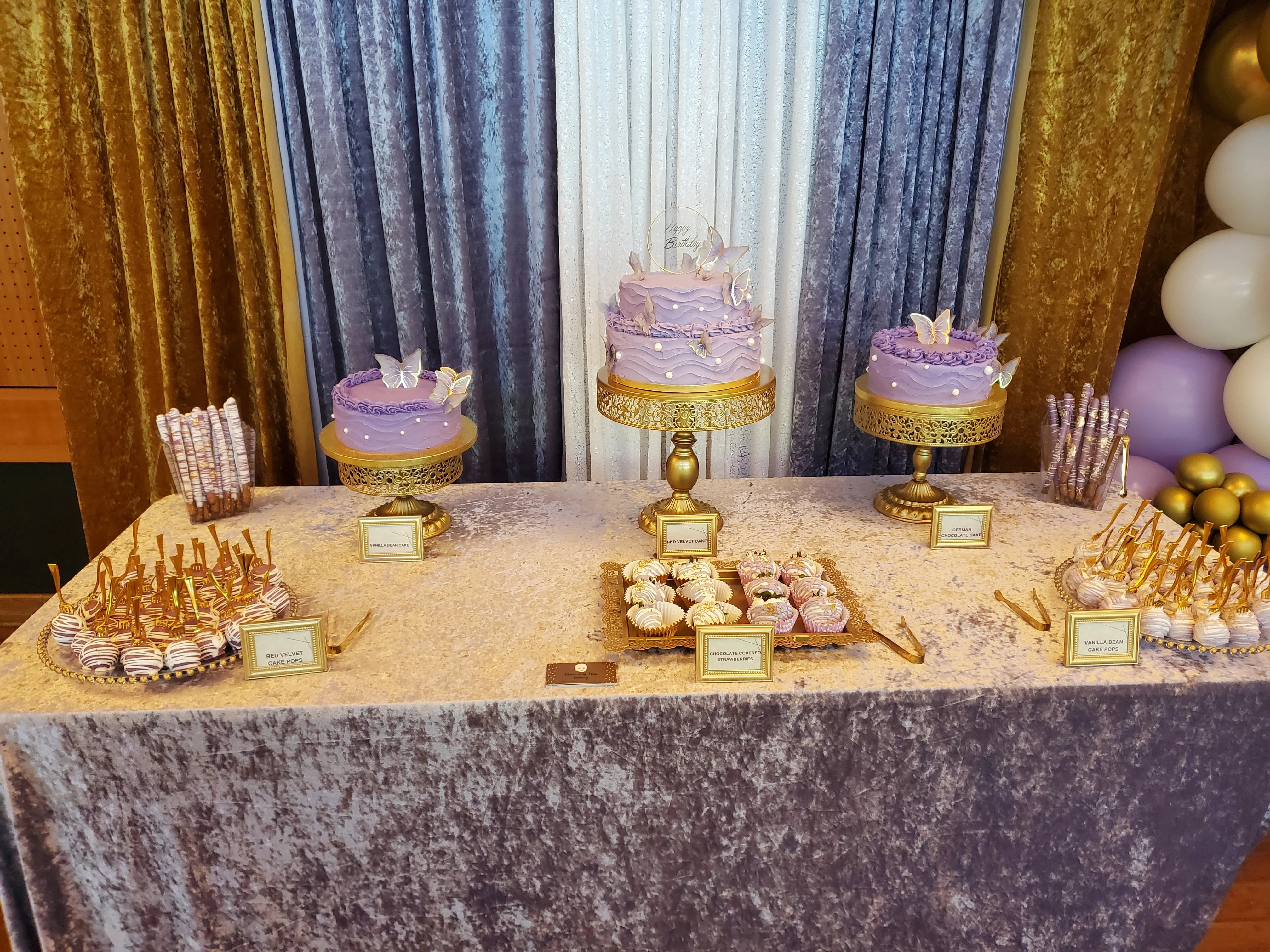 Elegant dessert table with purple cakes and treats for a celebration