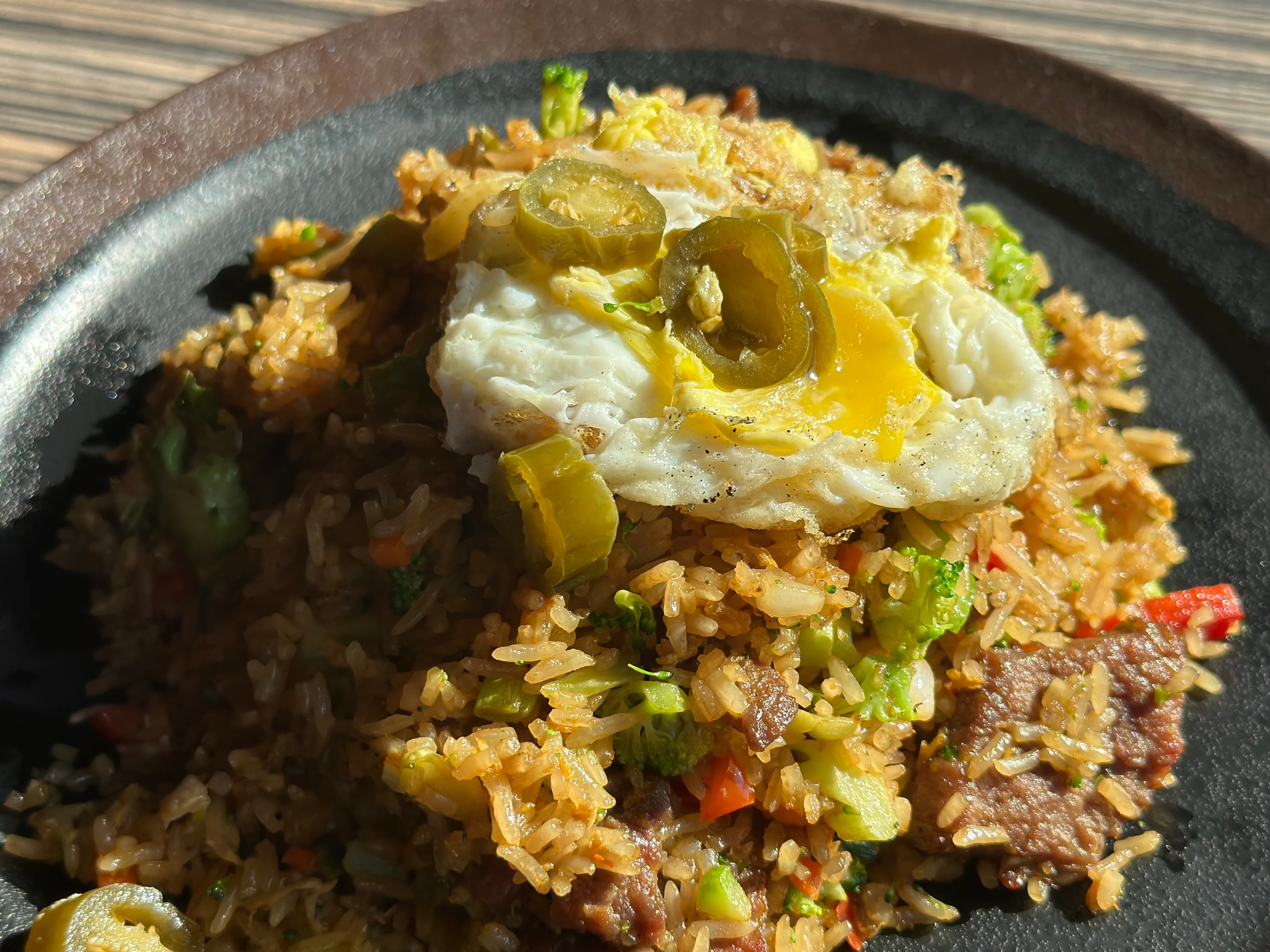 Fried rice topped with egg and jalapeños, a popular Asian dish