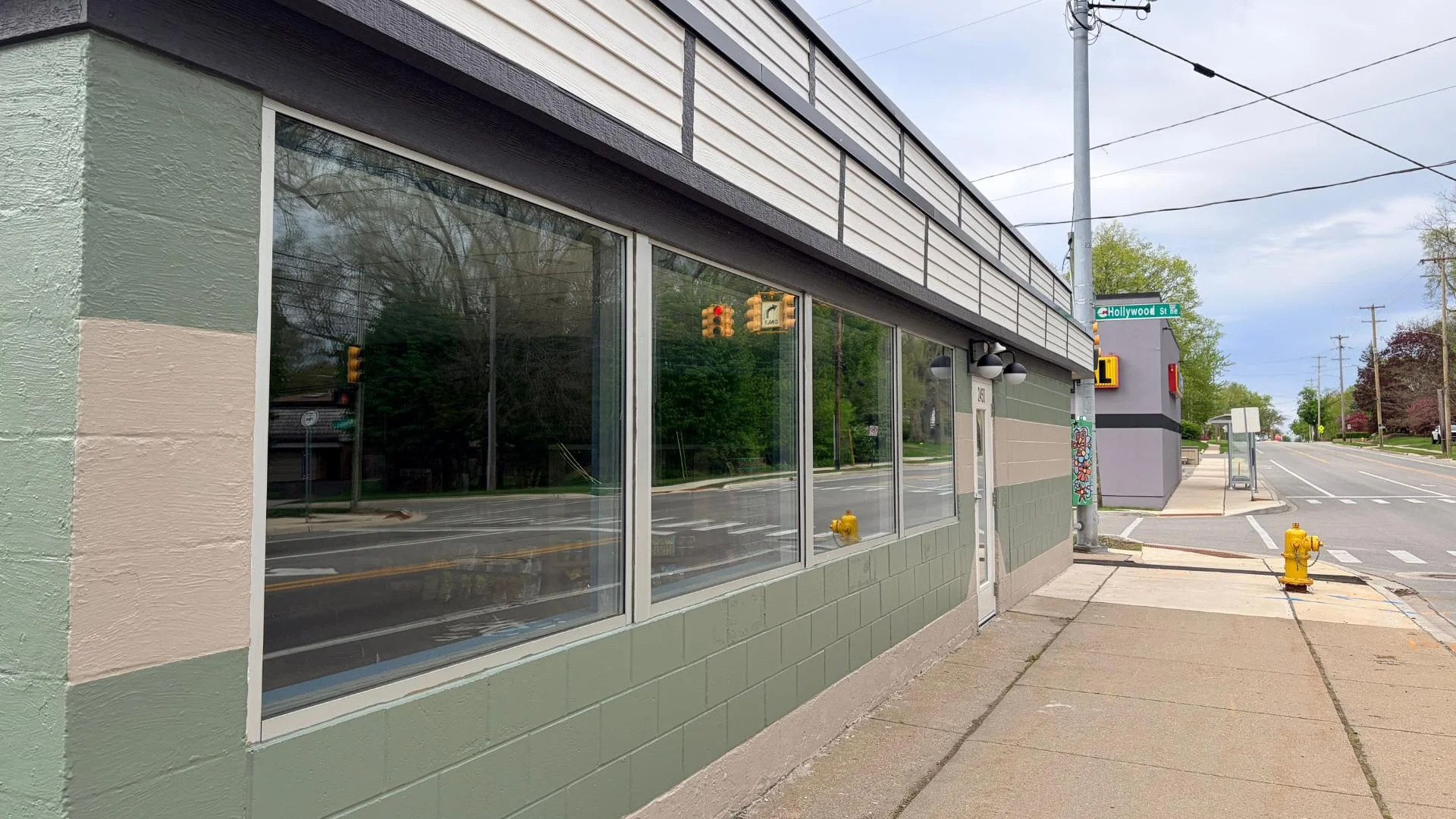 Exterior view of a restaurant with large windows and a street sign.