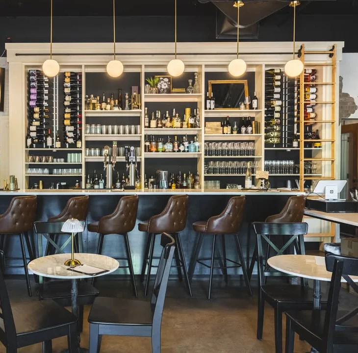Modern bar interior with stylish seating and a well-stocked shelf