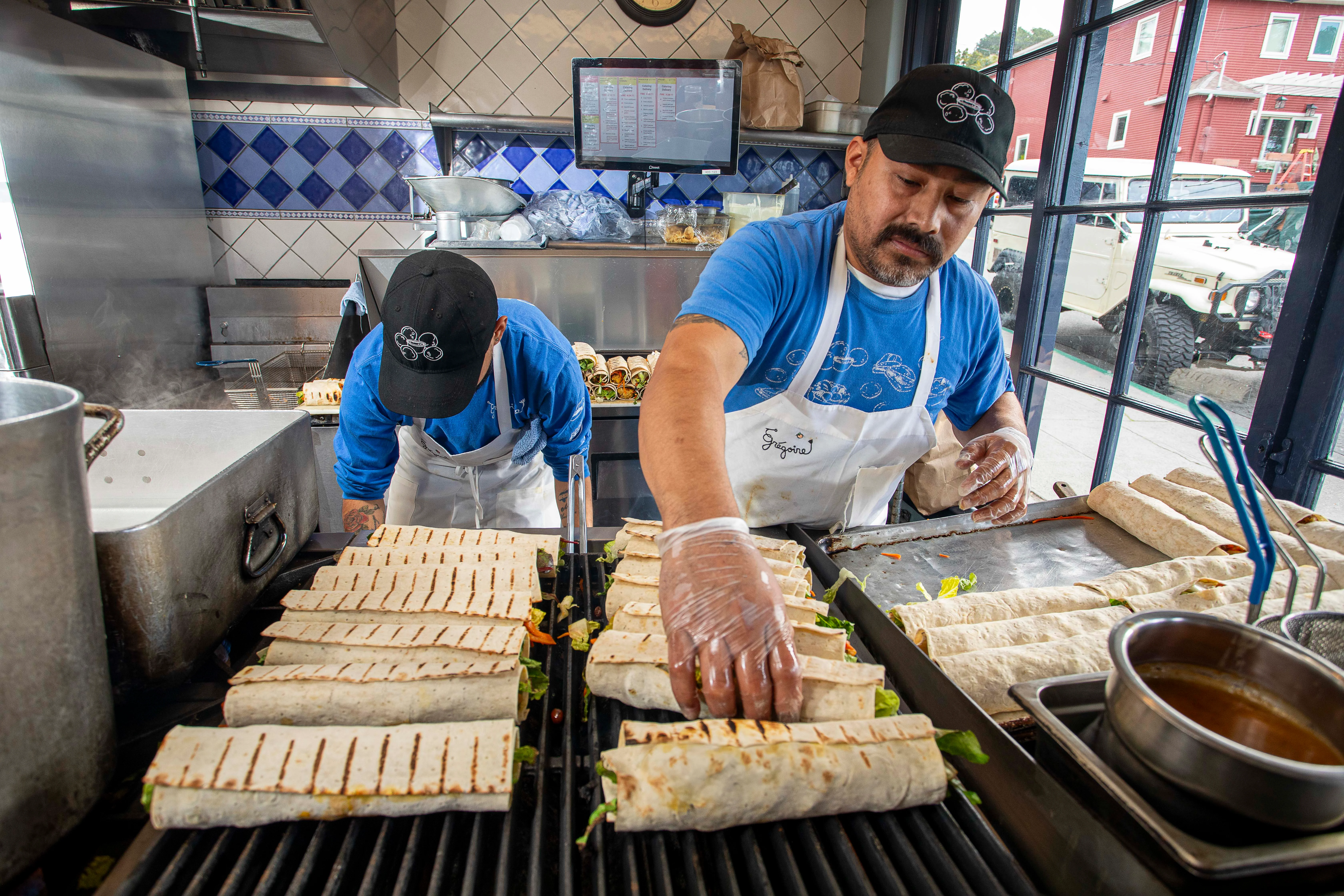 Grilled burritos being prepared in a vibrant kitchen