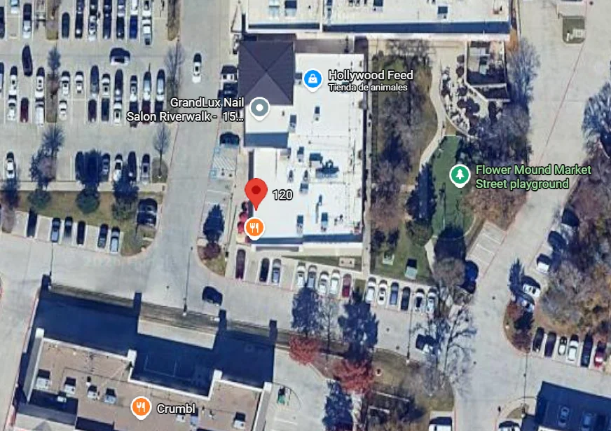 Aerial view of a restaurant location with nearby shops and parking