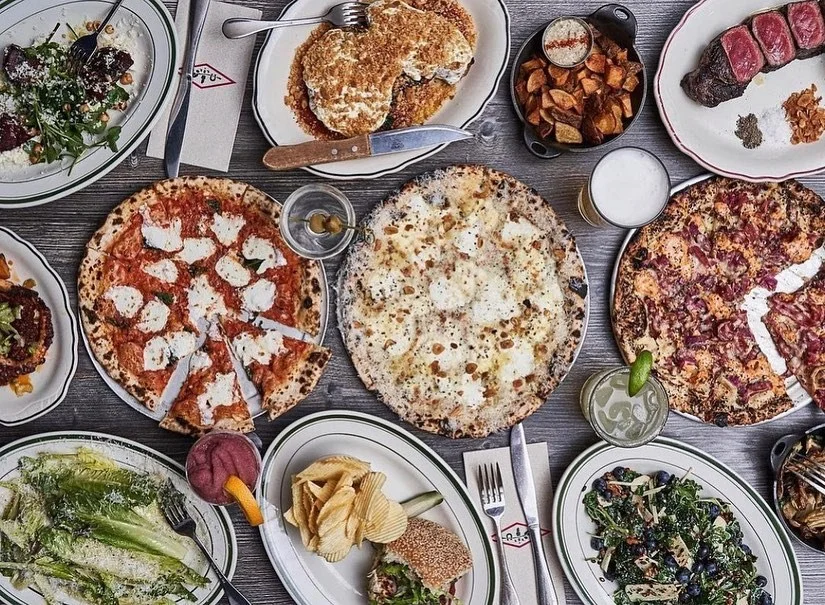 Variety of pizzas and dishes in a vibrant restaurant setting