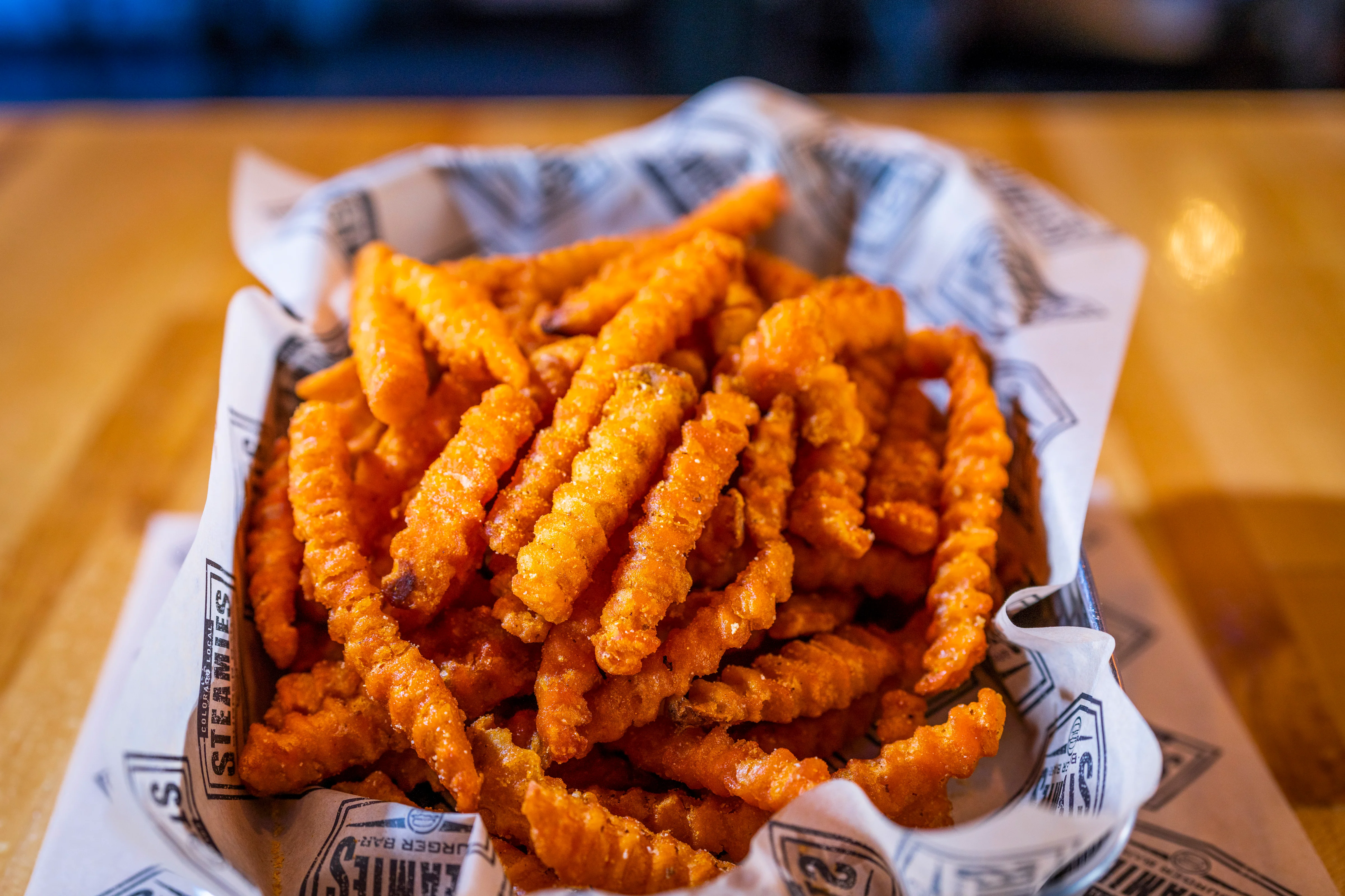 A basket filled with crispy crinkle-cut fries, ready to be enjoyed as a side dish.
