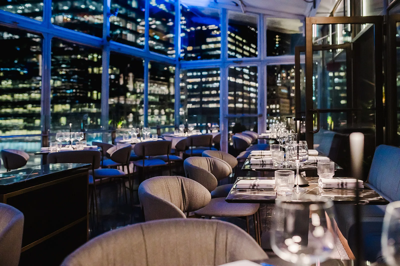 Elegant restaurant interior with city skyline views at night