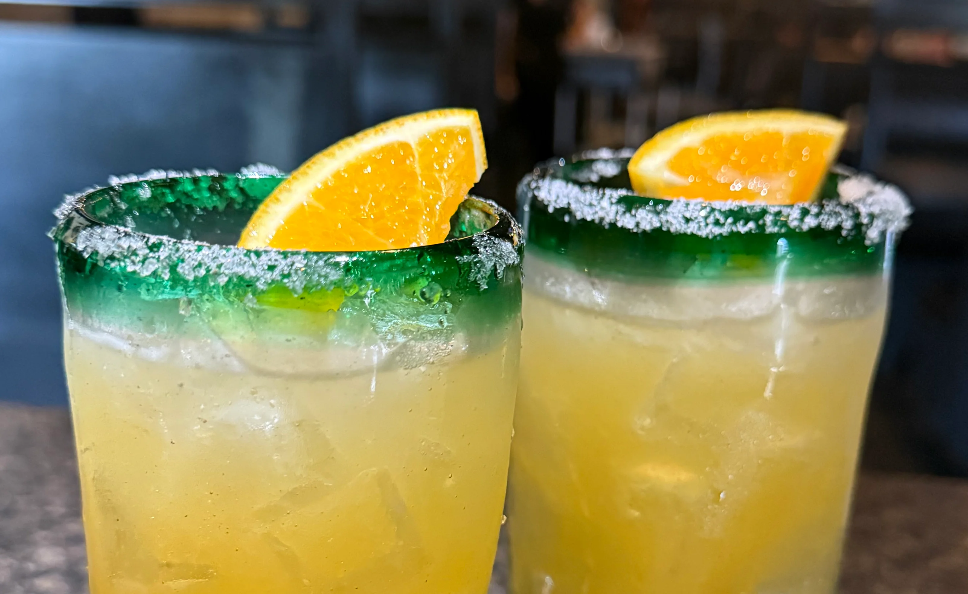 Colorful cocktails with orange garnish in a modern restaurant setting