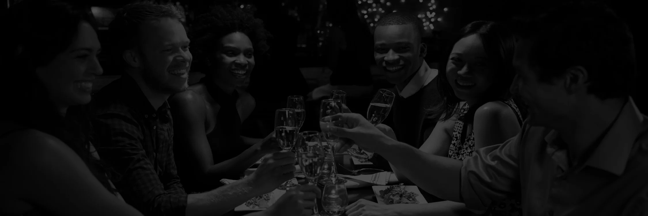 A group of friends raising their glasses in a toast while dining at Irina's Steak & Seafood, suggesting a celebratory atmosphere.