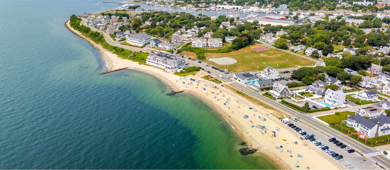 Aerial view of a coastal town with sandy beach and marina