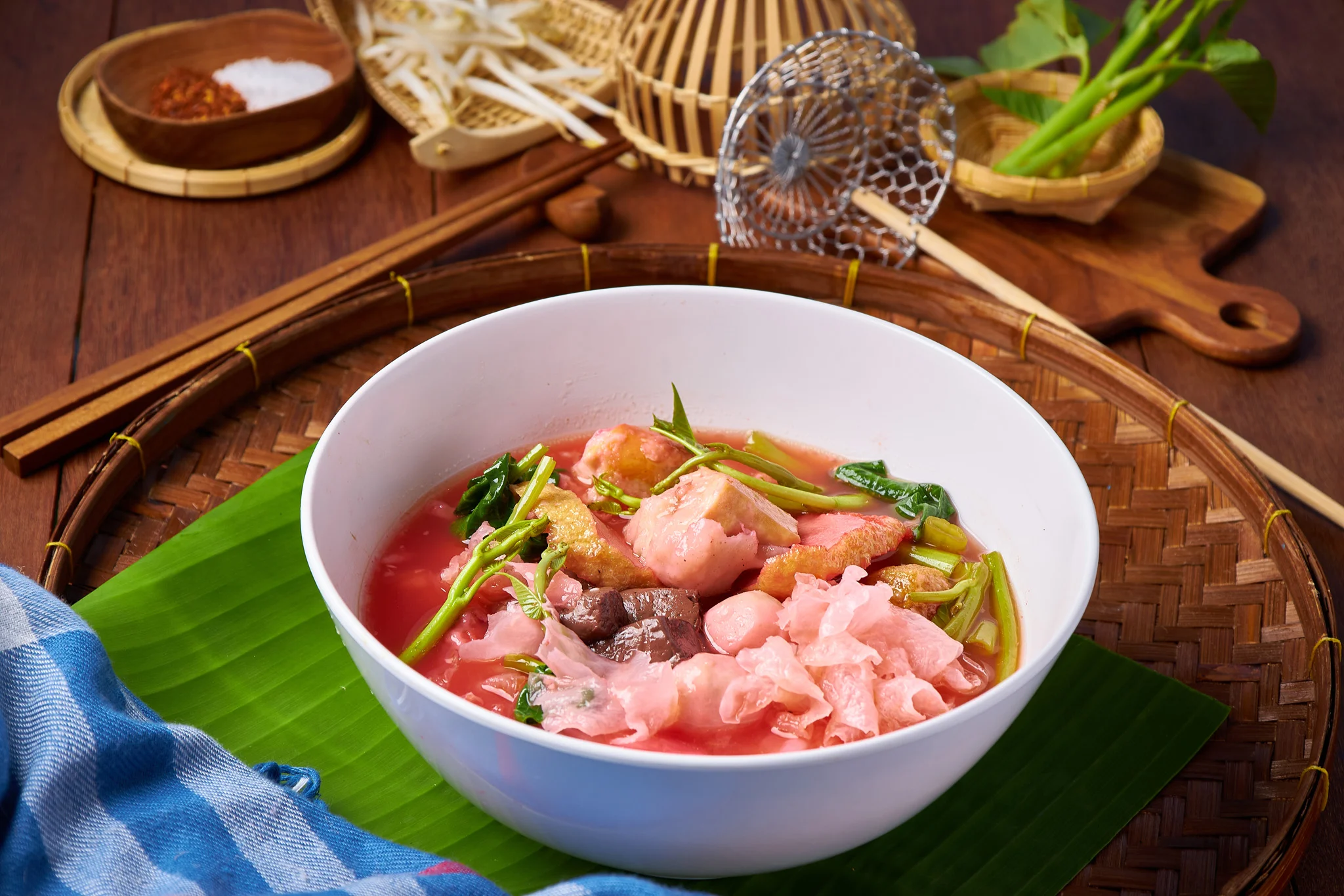 Bowl of Thai boat noodles with vibrant broth