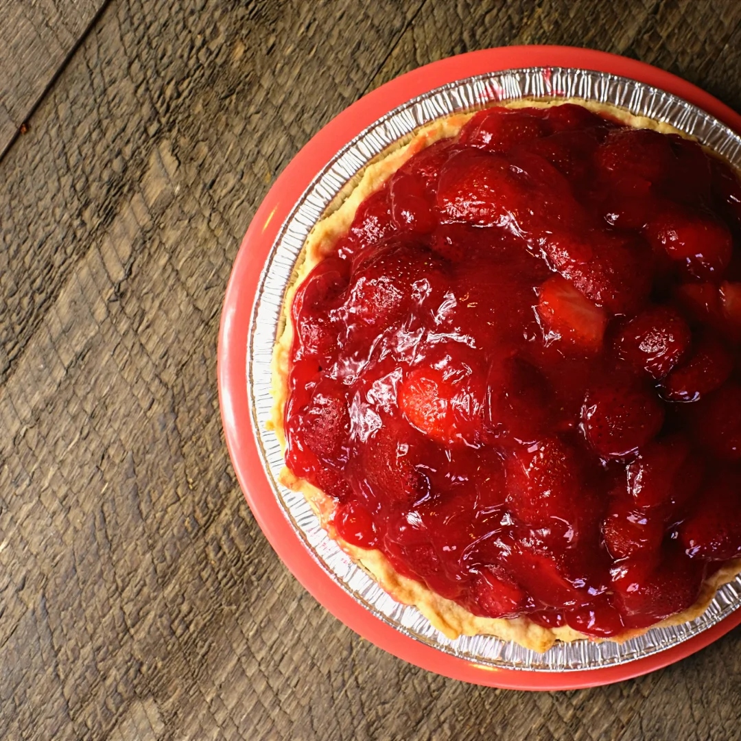 Classic strawberry pie on a rustic wooden table