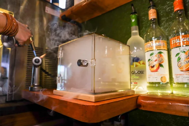 Bartender using a smoke box for cocktail preparation