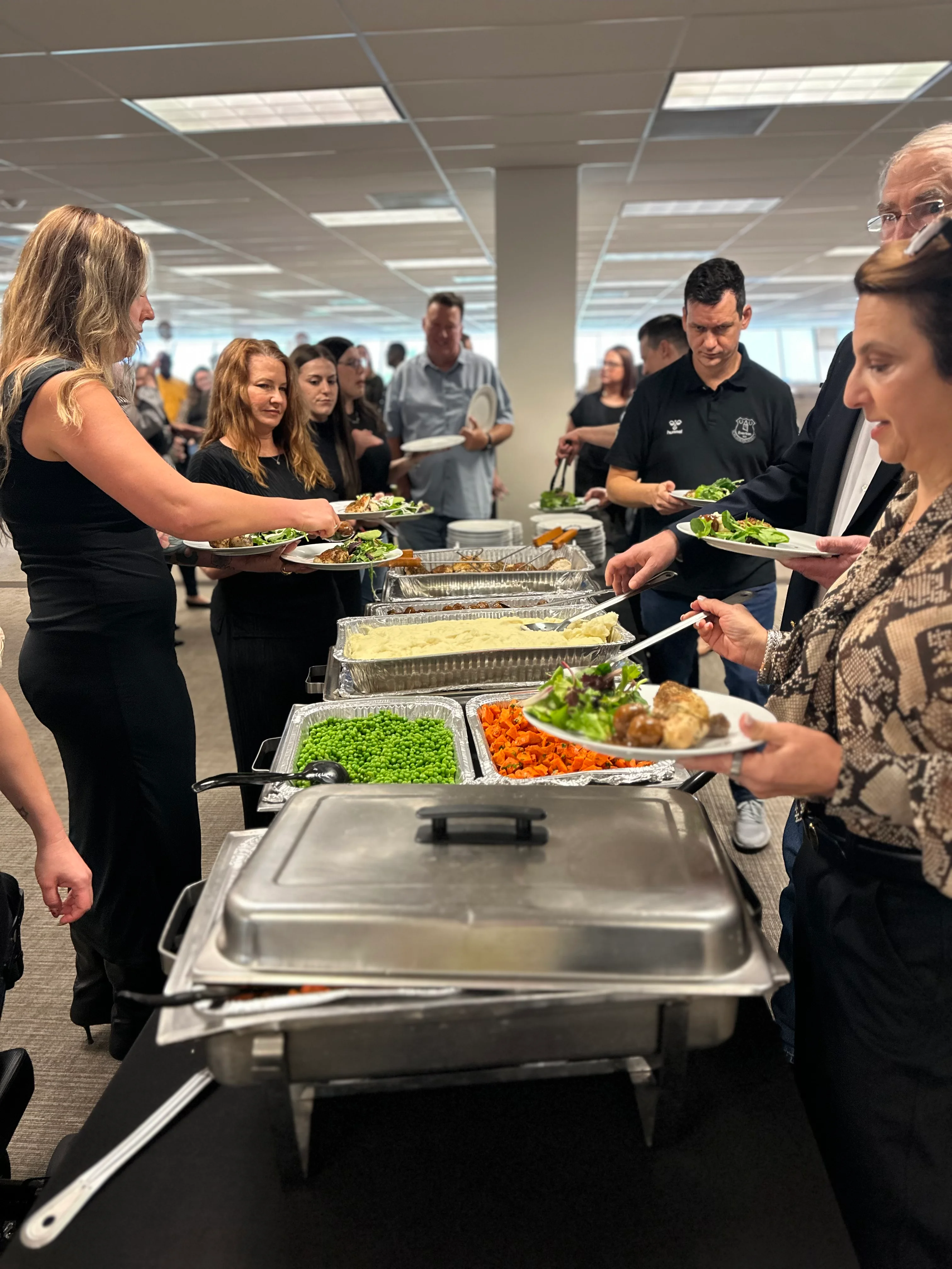 Catering buffet with assorted dishes and guests serving themselves