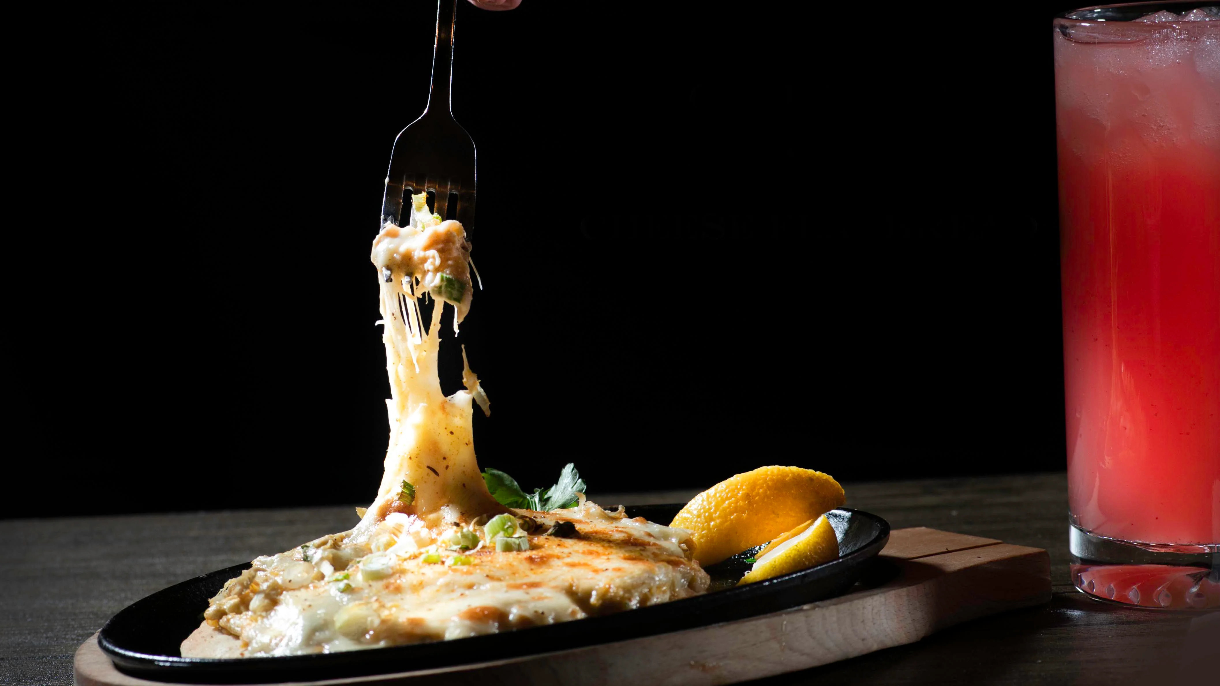 Cheesy Mexican queso fundido served with lemon wedges