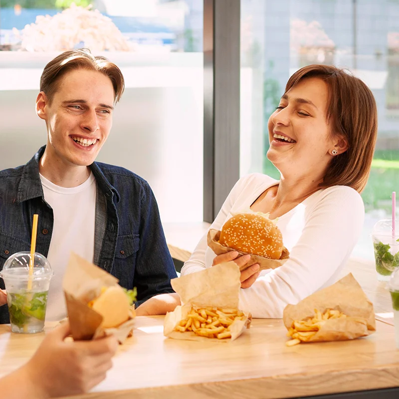 Friends enjoying burgers and fries in a bright restaurant