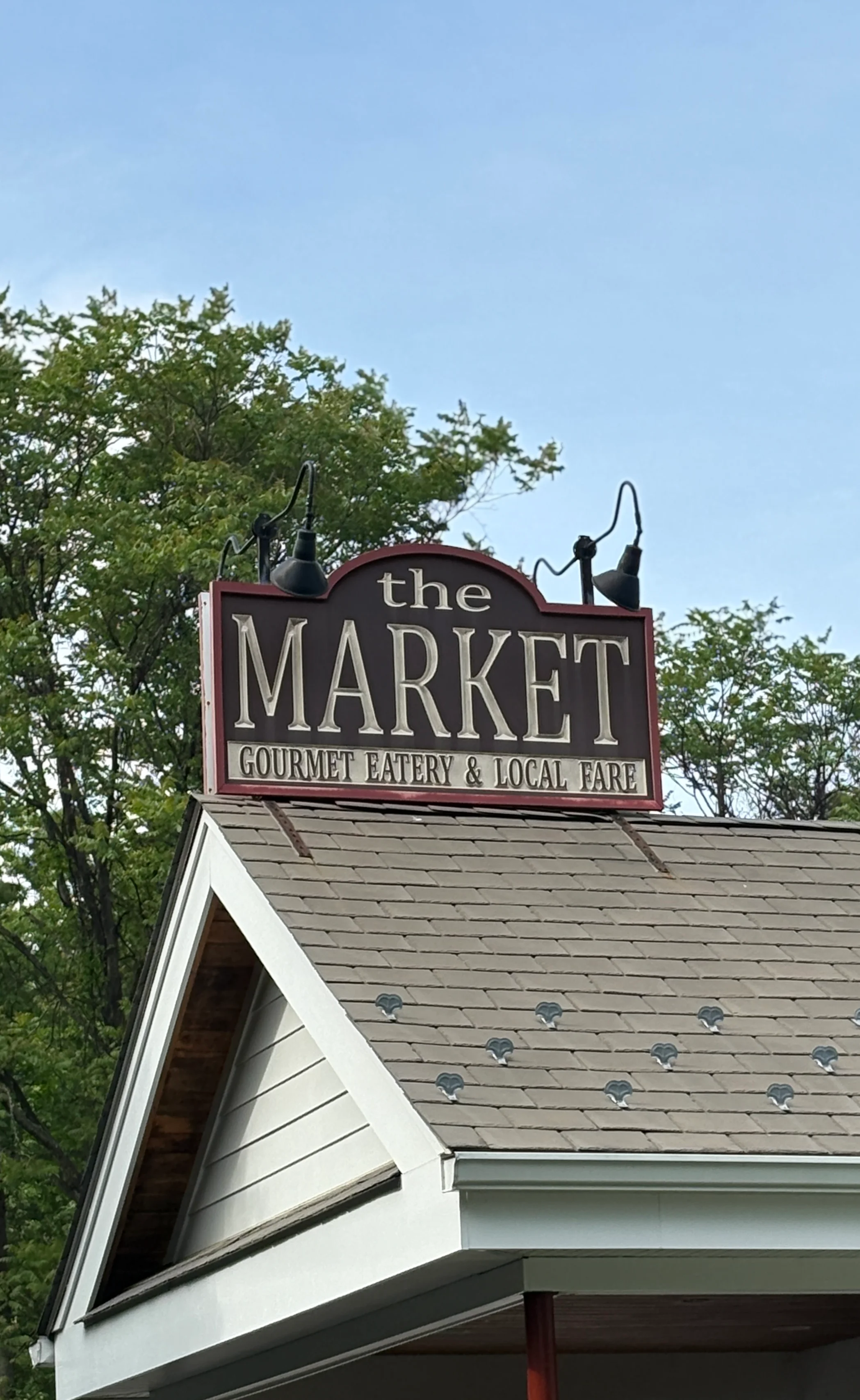 Sign of 'The Market' gourmet eatery showcasing local fare in a cozy setting.